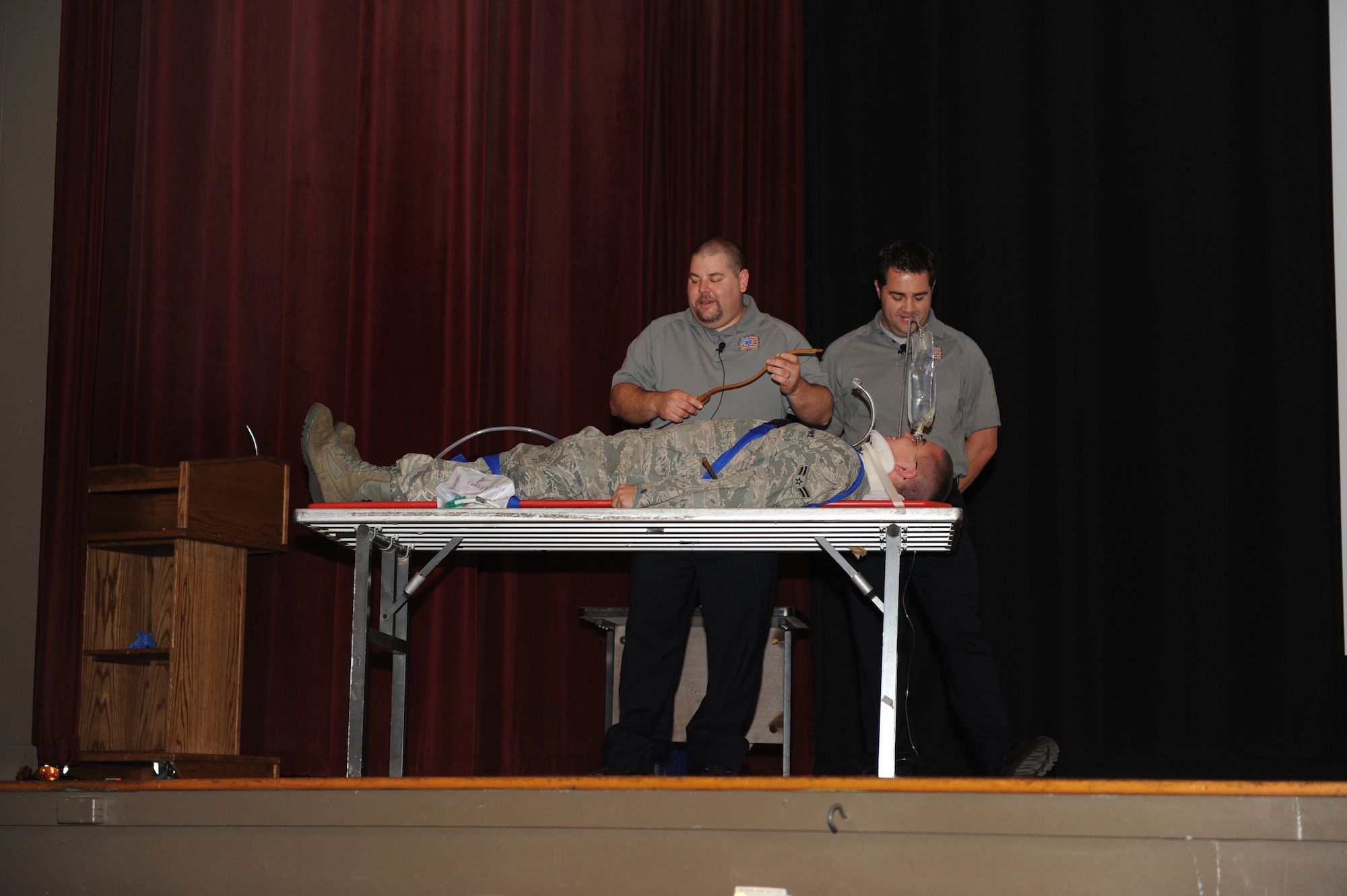Joseph McCluan and Scott McIntyre, both paramedic firefighters, explain to Airman 1st Class Zachery Mowrey, a 19th Equipment Maintenance Squadron aircraft metal technology apprentice, the procedures to save his life Nov. 9, 2010, after a mock car wreck during the Street Smart briefing at the base theater at Little Rock Air Force Base, Ark. The briefing was targeted for Airmen ages 18-26 to illustrate the dangers of making poor decisions such as drinking and driving, texting or not wearing their seatbelt. (U.S. Air Force photo by Airman 1st Class Ellora Stewart)