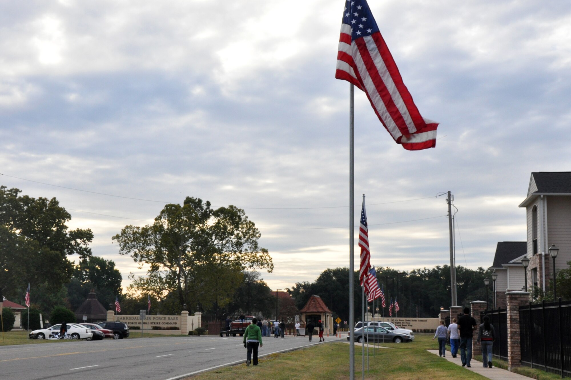 Barksdale Airmen walk back to their cars after placing 85 American flags along North Gate Road outside Barksdale Air Force Base, La., Nov. 11, 2010. Approximately 40 Airmen posted the flags to commemorate Veteran's Day. Volunteers for the flag detail came from Barksdale Team 56, the First Term Airman Center, Airman Leadership School - Class 11-02 and the 917th Wing. The flags lined the road for approximately a half mile from the North Gate to Patricia Drive, and were removed approximately 11 hours later, at the end of the day. (U.S. Air Force photo/Tech. Sgt. Jeff Walston)