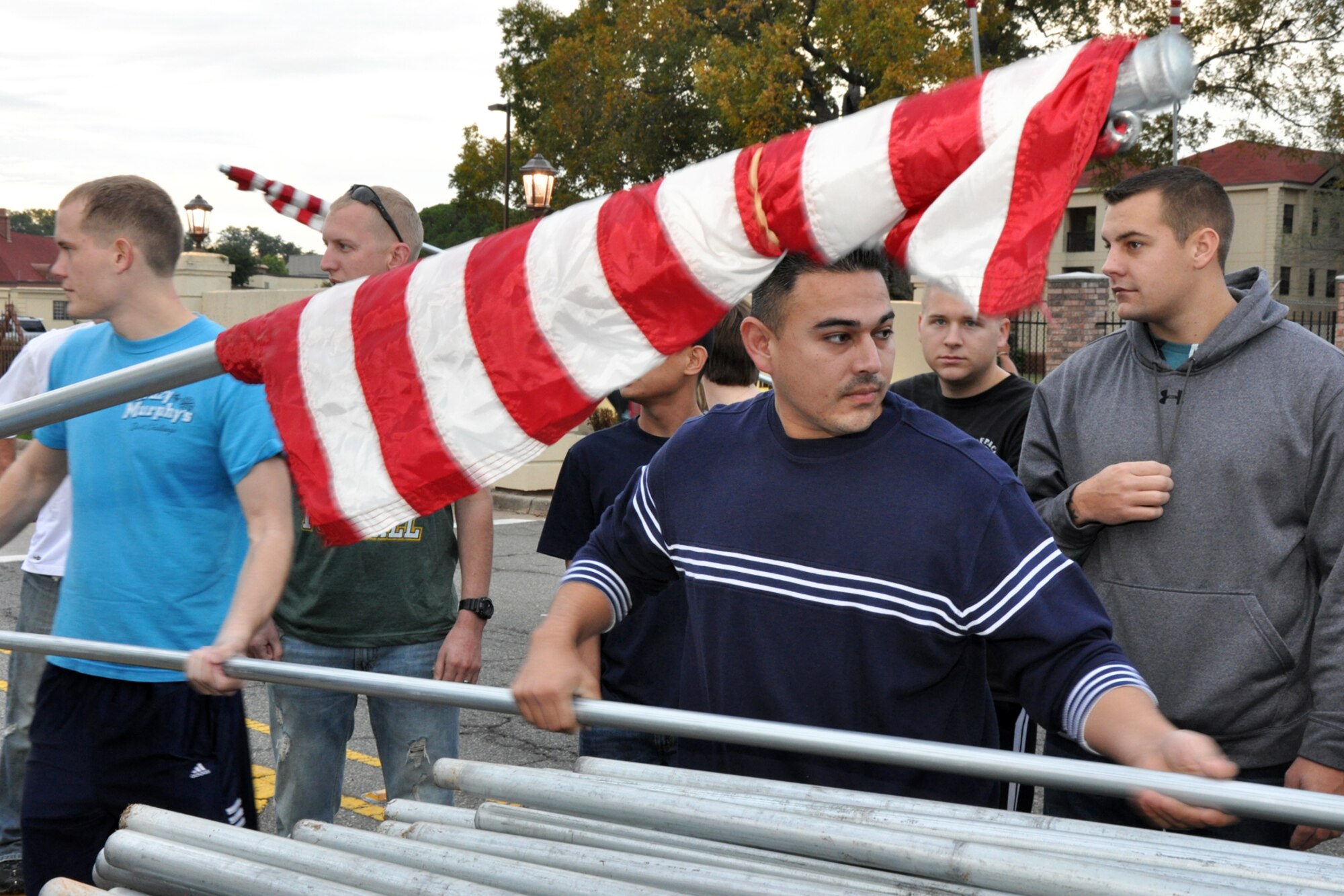 Staff Sgt. (S) Andrew Arellano, class leader, Class 11-02 Airman Leadership School, hands out one of 85 American Flags to approximately 40 Airmen who braved the early morning traffic to post the flags along North Gate Road from the North Gate to Patricia Drive at Barksdale Air Force Base, La, Nov. 11, 2010. Volunteers for the flag detail, which included another group of 17 Airmen putting up an additional 92 flags on base along Barksdale Air Force Base Boulevard, came from Barksdale Team 56, the First Term Airman Center, Airman Leadership School - Class 11-02 and the 917th Wing. The flags were removed approximately 11 hours later, at the end of the day. (U.S. Air Force photo/Tech. Sgt. Jeff Walston)