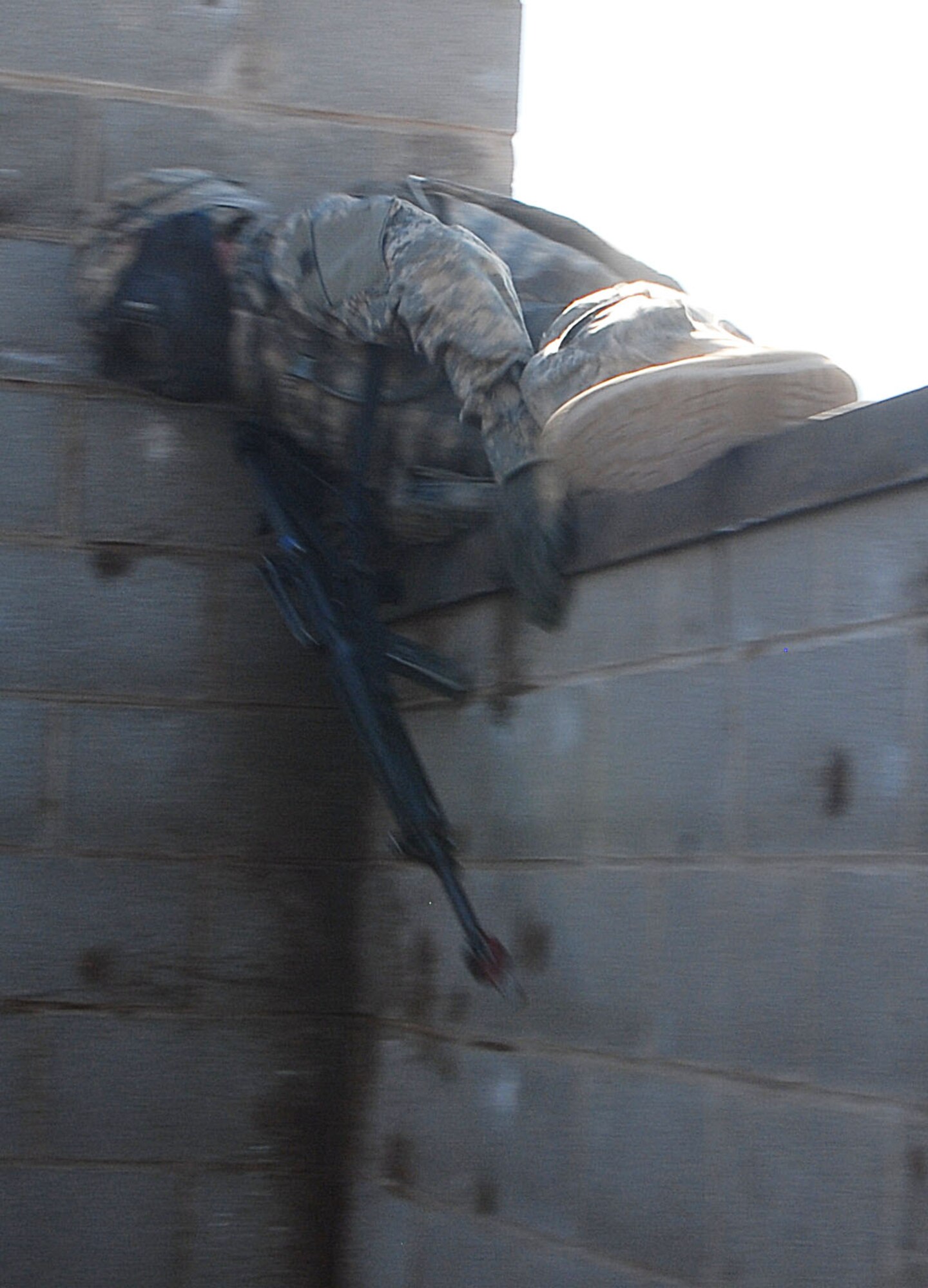 Army Private Brendan Raysor, 344th Military Intelligence Battation Alpha Company, jumps over a five-foot wall during a field training exercise at the Afghan Village here Oct. 10. The two-week exercise simulates life in a deployed environment and prepares students for life down range. (U.S. Air Force photo/Airman 1st Class Jessica D. Keith)