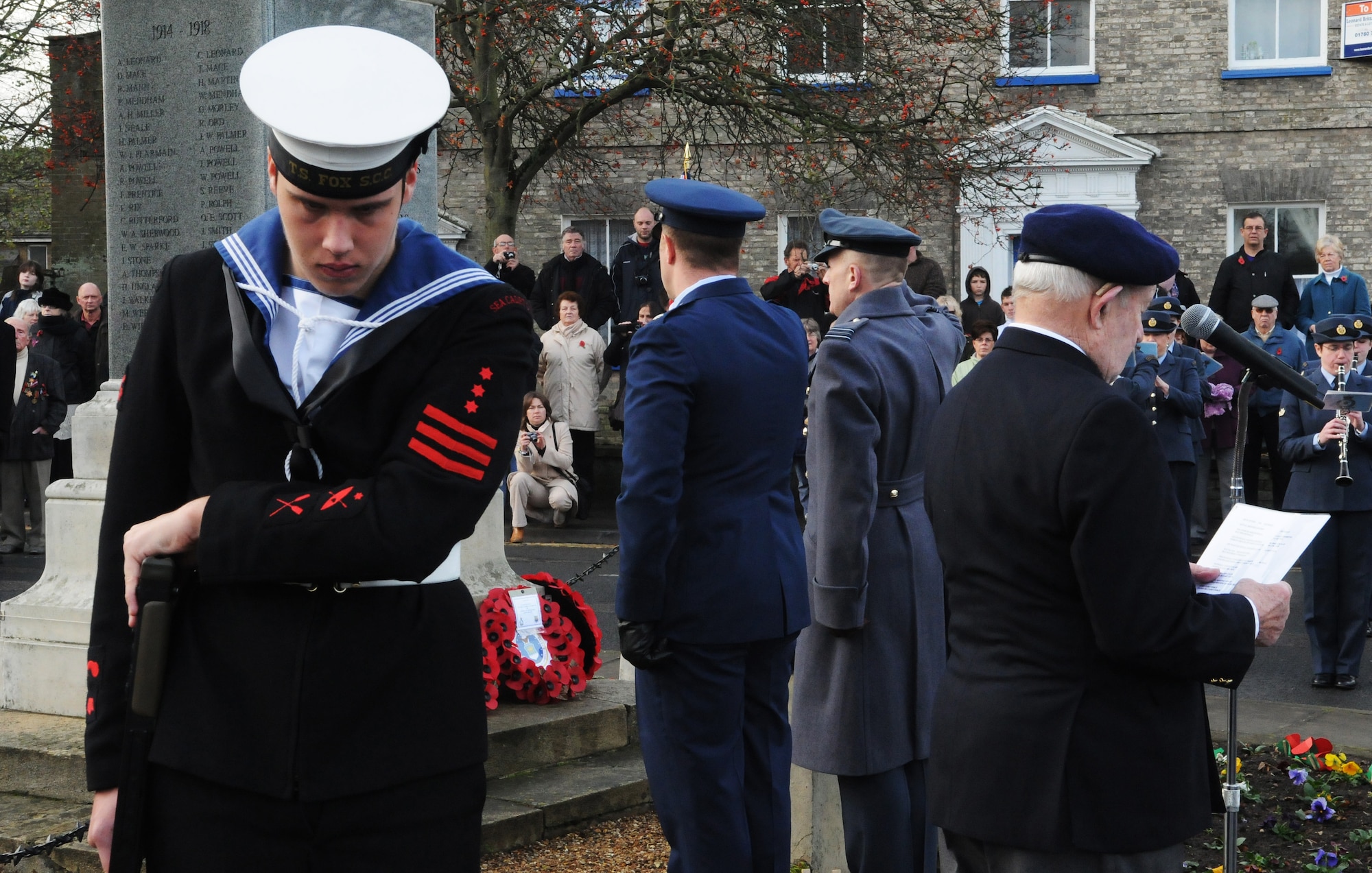 RAF MILDENHALL, England -- A representative of Training Ship Fox, Sea Cadet Corps, stands guard at the Mildenhall war memorial while Lt. Col. Michael Hammond, 100th Aircraft Maintenance Squadron commander, and Sqdn. Ldr. Rick Fryer, RAF Mildenhall station commander, present remembrance wreaths during a remembrance ceremony Nov. 14, 2010. Hundreds of townspeople came to pay their respects at the memorial dedicated to servicemembers who died in the two world wars as part of Remembrance Sunday events. (U.S. Air Force photo/Staff Sgt. Thomas Trower) 
