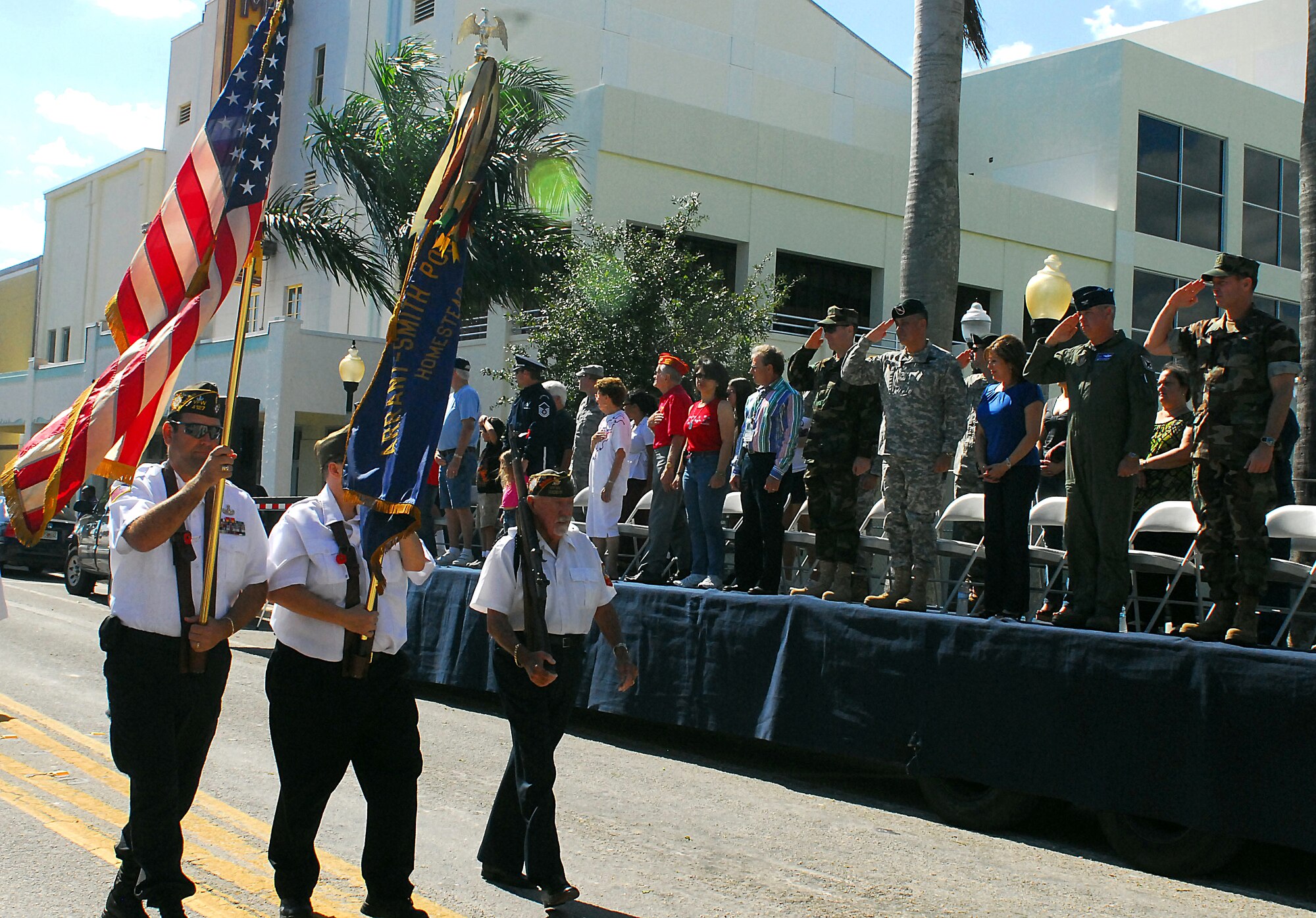 Members of the reviewing stand salute the U.S. flag during the Veterans Day parade held in historic downtown Homestead, Fla., Nov. 11. Members of the reviewing stand included Navy Rear Adm. Thomas L. Brown II, Commander, Special Operations Command South; retired Army Brig. Gen. Hector E. Pagan, former commander of SOCSOUTH; and Air Force Col. Ross R. Anderson, Commander, 482nd Fighter Wing Operations Group. Rear Adm. Brown and Col. Anderson served as Co-Grand Marshals of the parade. (SOCSOUTH photo/Sgt. 1st Class Alejandro Licea)