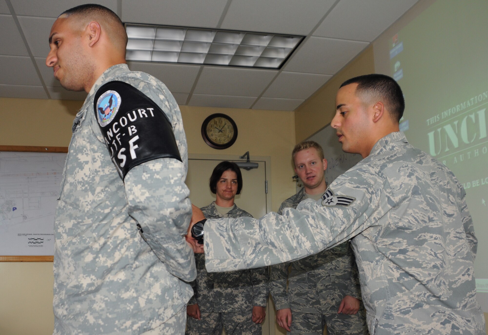 SOTO CANO AIR BASE, Honduras --  Senior Airman Jaime Perez, right, of the Joint Security Forces Squadron, shows augmentee trainees how to maintain control over a suspect, played by Spc. Dionny Betancourt, of the JSF, before handcuffing him here recently. (U.S. Air Force photo/Tech. Sgt. Benjamin Rojek)