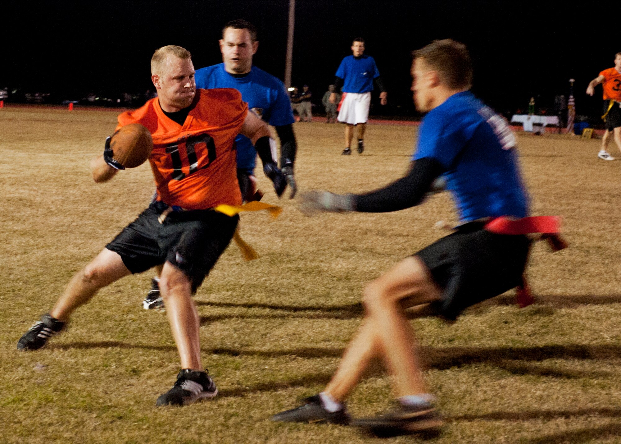 Jon Bowling, Air Force Research Lab, tries to spin away from 53rd Wing defenders during the base intramural championship game, Nov. 10.  AFRL defeated the 53rd (14-12) in the second of two games to win back-to-back base titles.  The 53rd team gave AFRL its only loss of the season, (20-19) earlier in the evening, forcing a winner-take-all game in the double-elimination tournament.  (U.S. Air Force photo/ Samuel King Jr.)
