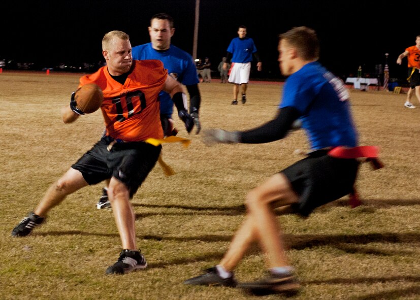 Jon Bowling, Air Force Research Lab, tries to spin away from 53rd Wing defenders during the base intramural championship game, Nov. 10.  AFRL defeated the 53rd (14-12) in the second of two games to win back-to-back base titles.  The 53rd team gave AFRL its only loss of the season, (20-19) earlier in the evening, forcing a winner-take-all game in the double-elimination tournament.  (U.S. Air Force photo/ Samuel King Jr.)
