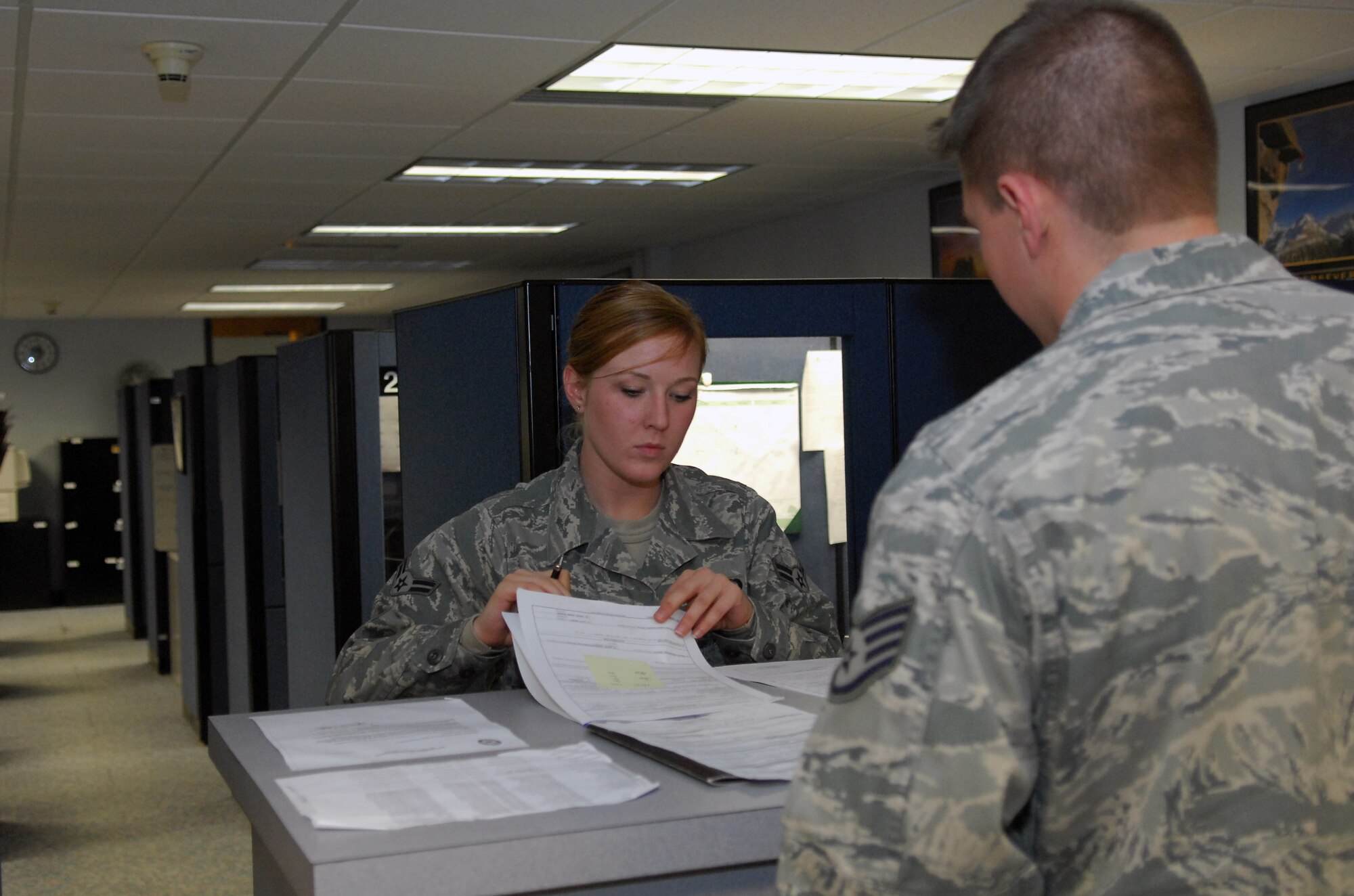 Airman 1st Class Ashley LaGrow, 43rd Comptroller Squadron customer finance technician, assists a customer with filling his travel voucher Nov. 4. 43rd CPTS customer service technicians, such as Airman LaGrow, are dedicated to providing the best customer service possible. (U.S. Air Force photo/Senior Airman Kris Levasseur)