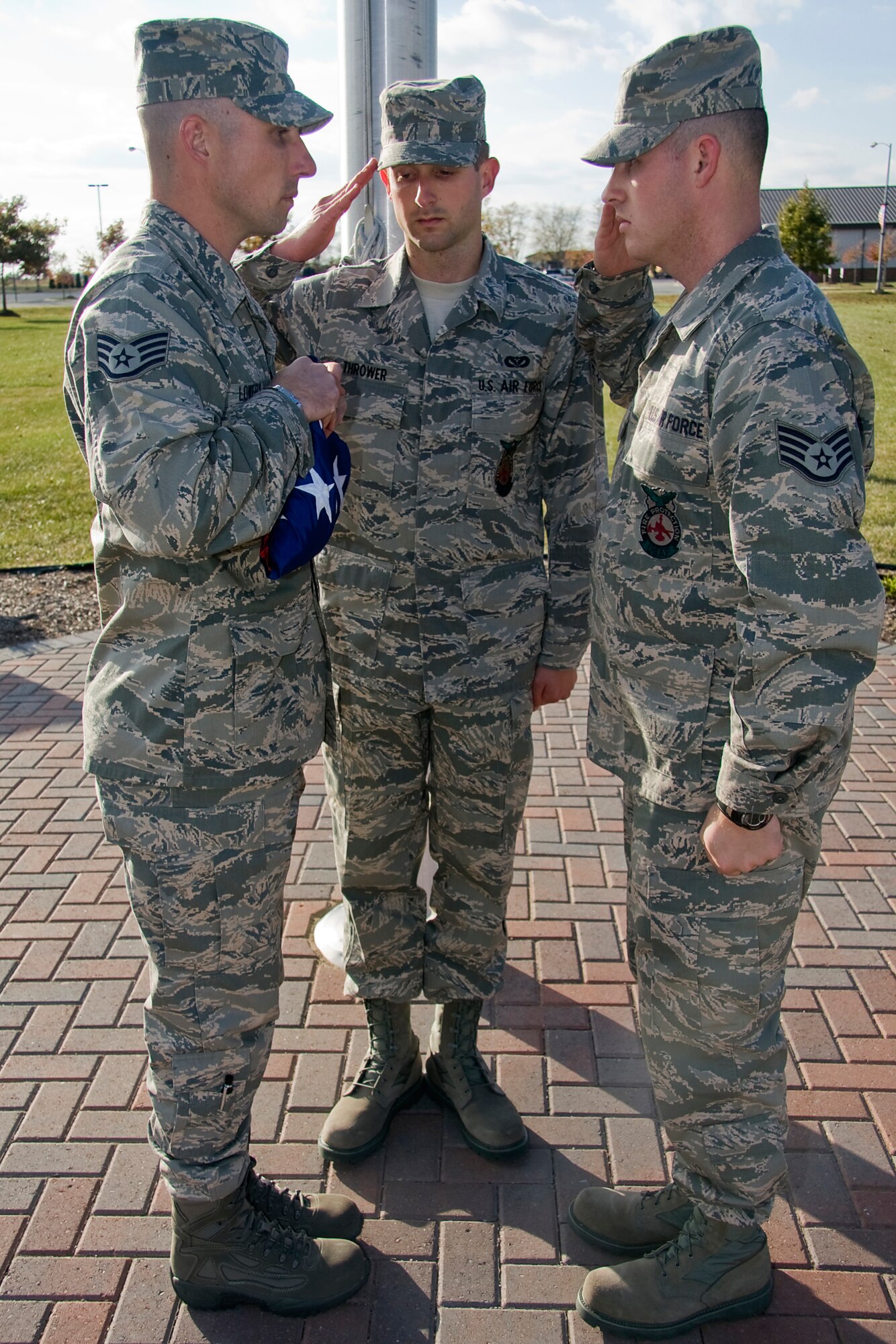 GRISSOM AIR RESERVE BASE, Ind. -- From the left, Staff Sgt. Christopher Lowery, Senior Airman Christopher Thrower and Staff Sgt. Jeff Schlageter pay tribute to the flag during a retreat ceremony held here during the November unit training assembly. All three Airmen are fire protection specialists with the 434th Civil Engineer Squadron. Retreat ceremonies are held each day at Grissom and serve a two-fold purpose. They signal the end of the official duty-day and serve as a ceremony for paying respect to the flag. (U.S. Air Force photo/Tech. Sgt. Mark R. W. Orders-Woempner)
