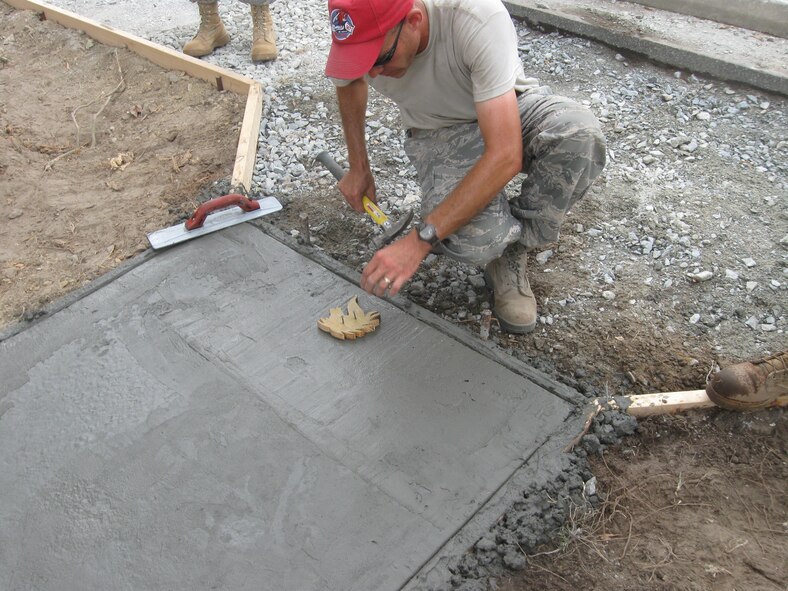 Master Sgt. Dan Connolly imprints the RED HORSE logo into the concrete. (USAF photo courtesy of 567RHS)