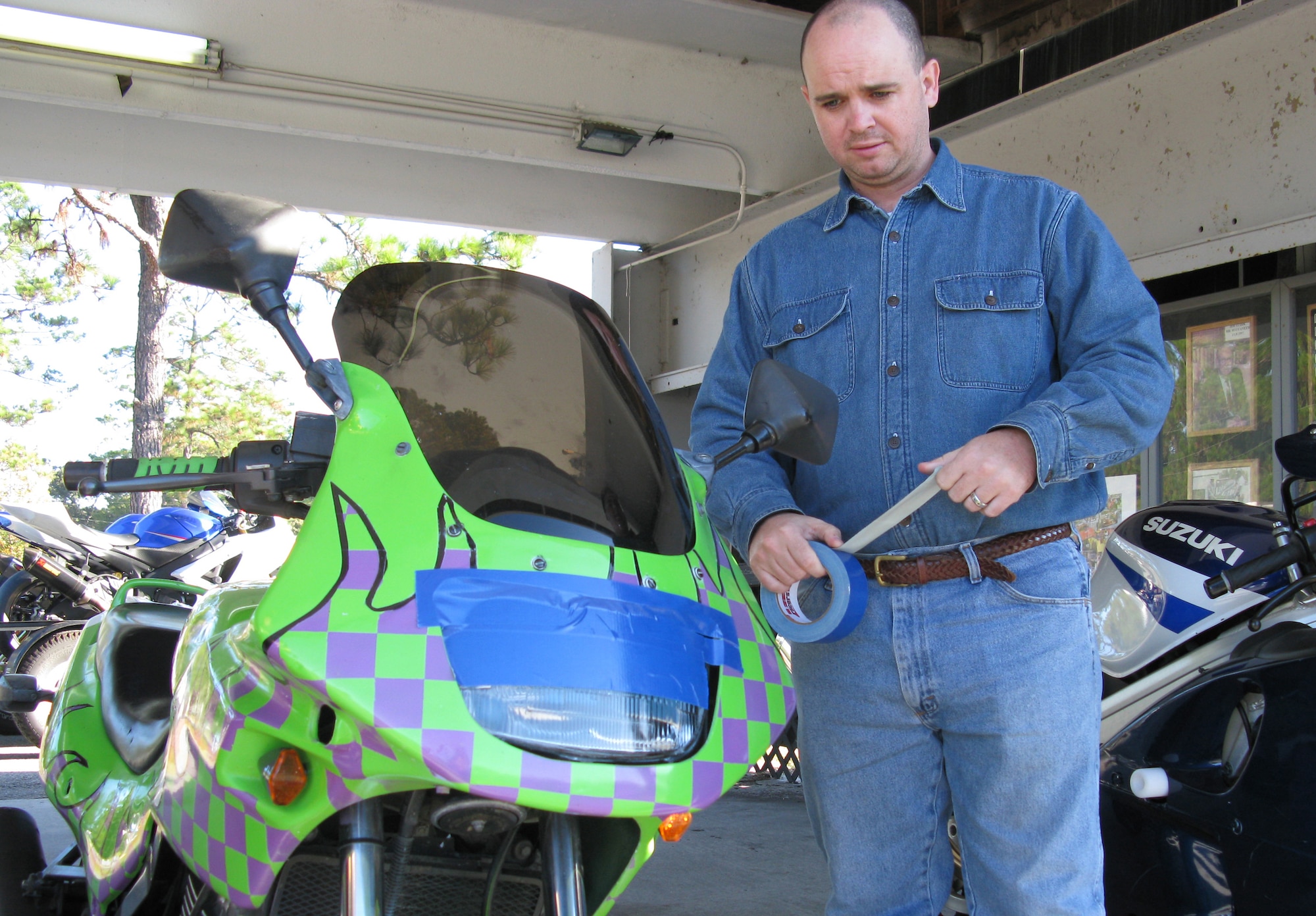 Master Sgt. David Simms masks the headlights and other parts on a motorcycle at Roebling Road Track in Bloomingdale, Ga., Nov. 8 during the Air Force Reserve Command motorcycle safety stand down day. Masking the parts prevents glass and plastic parts from shattering on the track if the rider lays the bike down.  AFRC Safety Office offered the one-day course to help military motorcycle riders practice skills that will help them negotiate hazards on the road. (U.S. Air Force photo/Master Sgt. Rachael Cox)