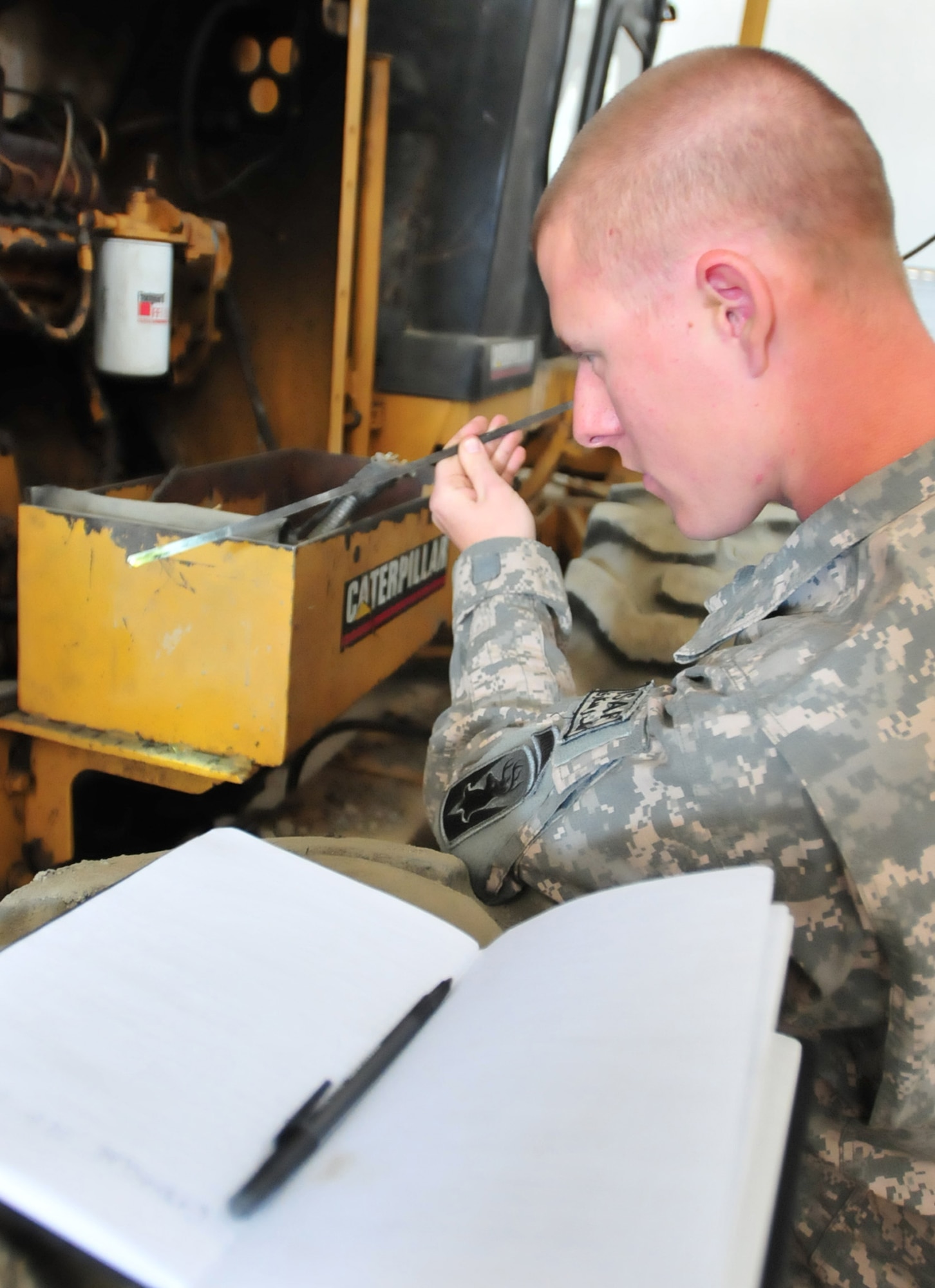 PANJSHIR PROVINCE, Afghanistan ? U.S. Air Force Staff Sgt. Michael Lamonte, Panjshir Provincial Reconstruction Team vehicle maintenance lead mechanic and Burlington, Conn., native, checks the oil on an earth grader belonging to Panjshir Department of Public Works.  Sergeant Lamonte performs a preventative maintenance inspection and identifies discrepancies to Panjshir Director of Public Works Aziz Jalile prior to the vehicle?s operation.  (U.S. Air Force Photo by Tech. Sgt. Sean Mateo White, Panjshir Provincial Reconstruction Team Photographer)