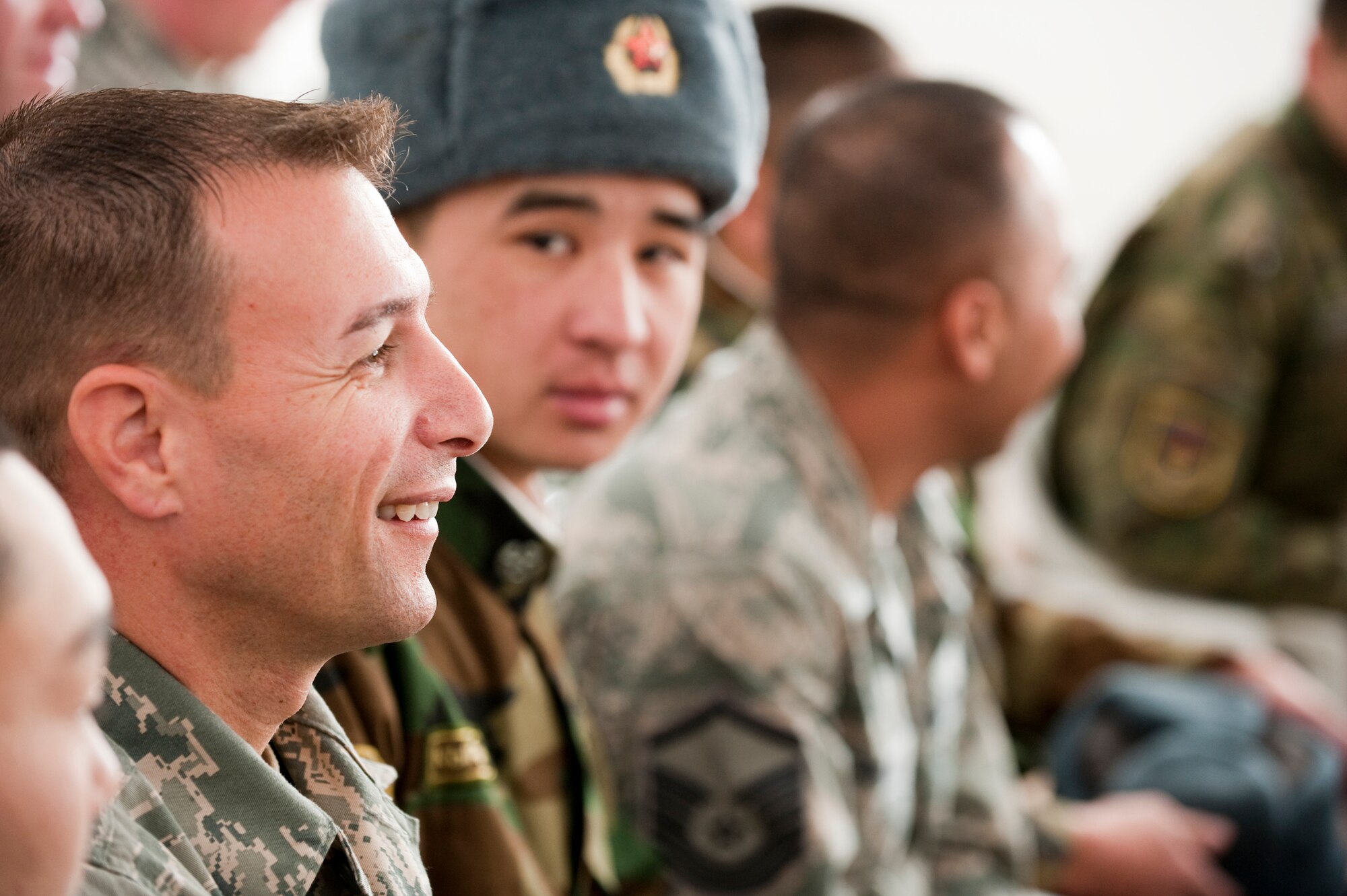 KOI-TASH, Kyrgyzstan - Master Sgt. John Lamp, a first sergeant at the Transit Center at Manas, sits amongst U.S. and Kyrgyz service members during a cultural concert by students at the Chuiskaya Region Boarding School-Gymnasium Nov. 11. The two militaries gave students warm coats and hats as part of Operation Warm and Dry II. (U.S. Air Force Photo/Tech. Sgt. Jennifer Buzanowski)