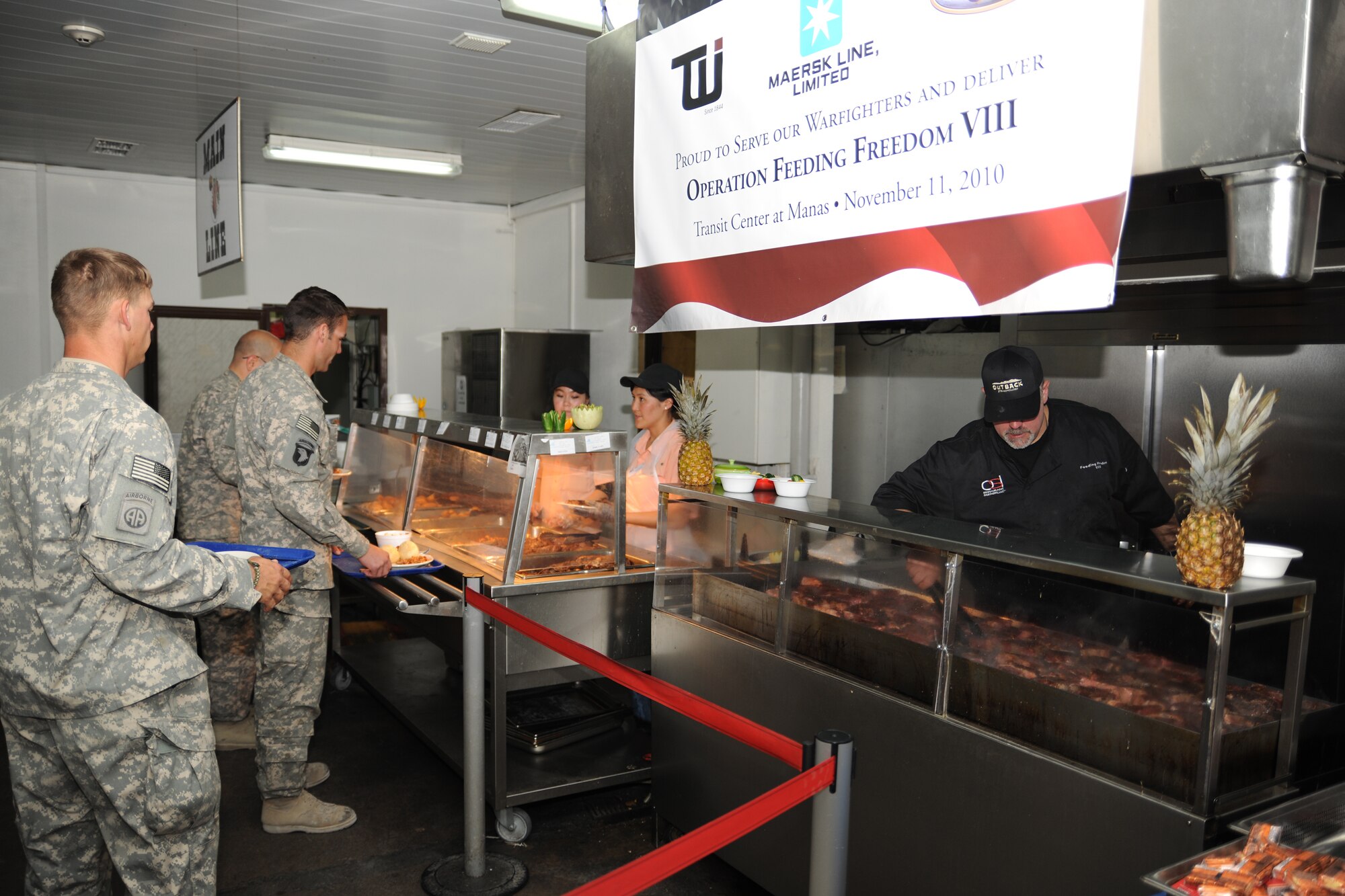 TRANSIT CENTER AT MANAS, Kyrgyzstan - Deployed military troops receive meals prepared by Outback Steakhouse Incorporated (OSI) employees during an Armed Forces Entertainment tour to the Transit Center at Manas Nov. 11.  OSI owns Outback Steakhouse, Carrabba's Italian Grill, Bonefish Grill, Fleming's Prime Steakhouse and Wine Bar and Roy's Hawaiian Fusion Cuisine.  Employees volunteered to visit with the troops and prepared 4,400 meals here in celebration of Veterans Day.   (U.S. Air Force photo/Staff Sgt. Nathan Bevier)