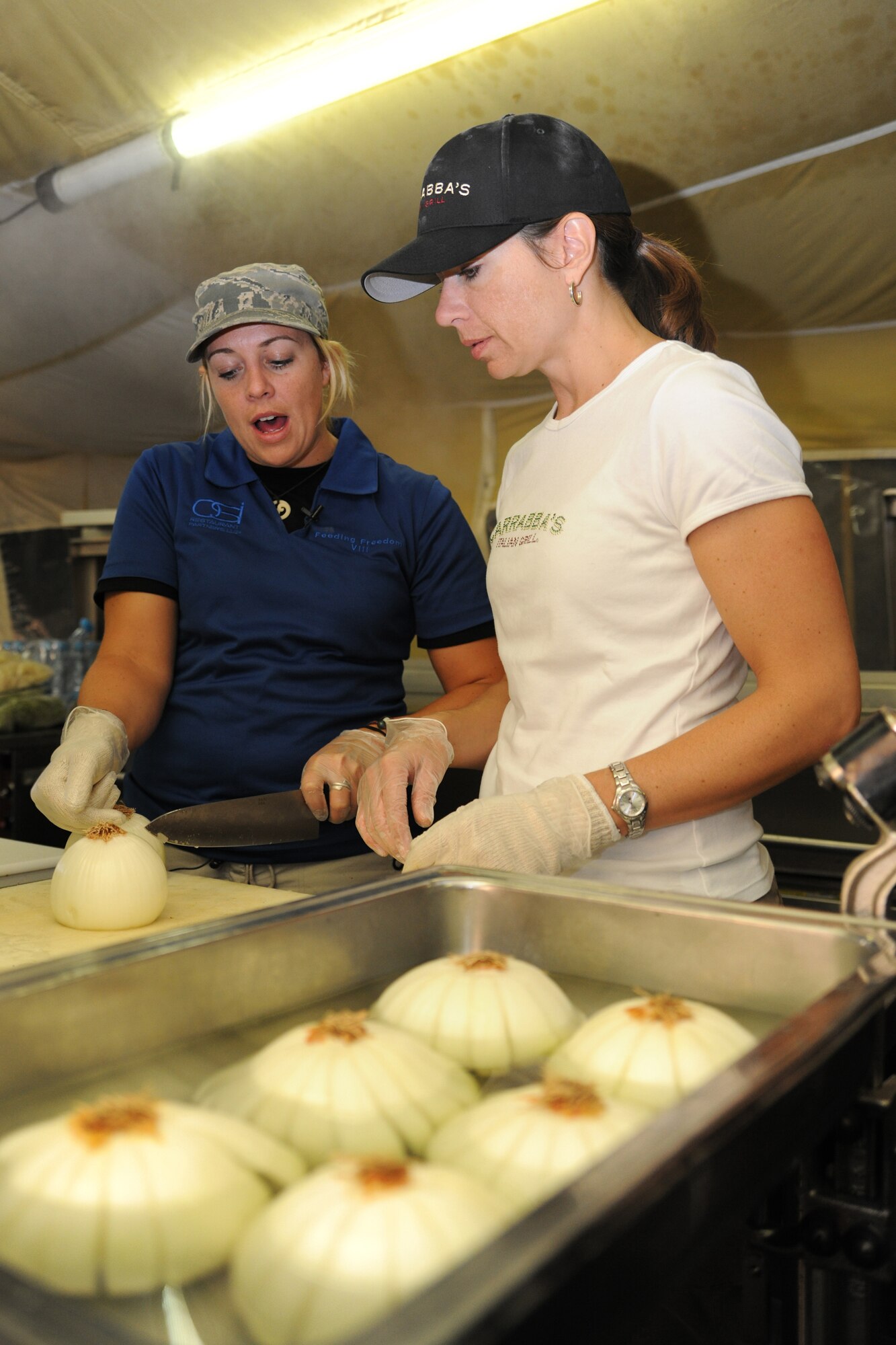 TRANSIT CENTER AT MANAS, Kyrgyzstan - Outback Steakhouse Incorporated (OSI) employees prepare onions by hand during an Armed Forces Entertainment tour to the Transit Center at Manas Nov. 10.  OSI owns Outback Steakhouse, Carrabba's Italian Grill, Bonefish Grill, Fleming's Prime Steakhouse and Wine Bar and Roy's Hawaiian Fusion Cuisine.  Employees volunteered to visit with the troops and prepared 4,400 meals here in celebration of Veterans Day.   (U.S. Air Force photo/Staff Sgt. Michael Schocker)