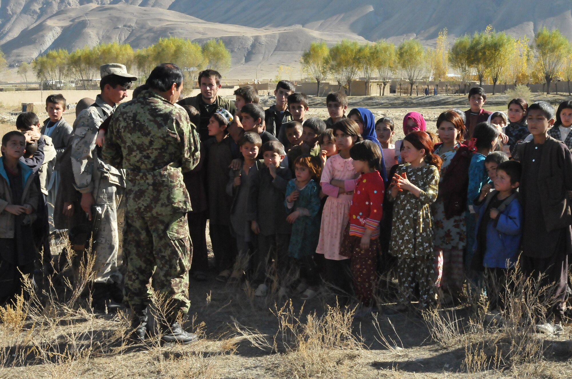 BAHARAK, Afghanistan -- An Afghan Air Force general officer addresses a group of children during a humanitarian assistance mission in the town of Baharak in Badakhshan province. U.S., Afghan and coalition forces are supporting efforts by the non-governmental organization Global Roots to build an orphanage in the area (US Navy photo by MC2 Vladimir V. Potapenko/RELEASED).


