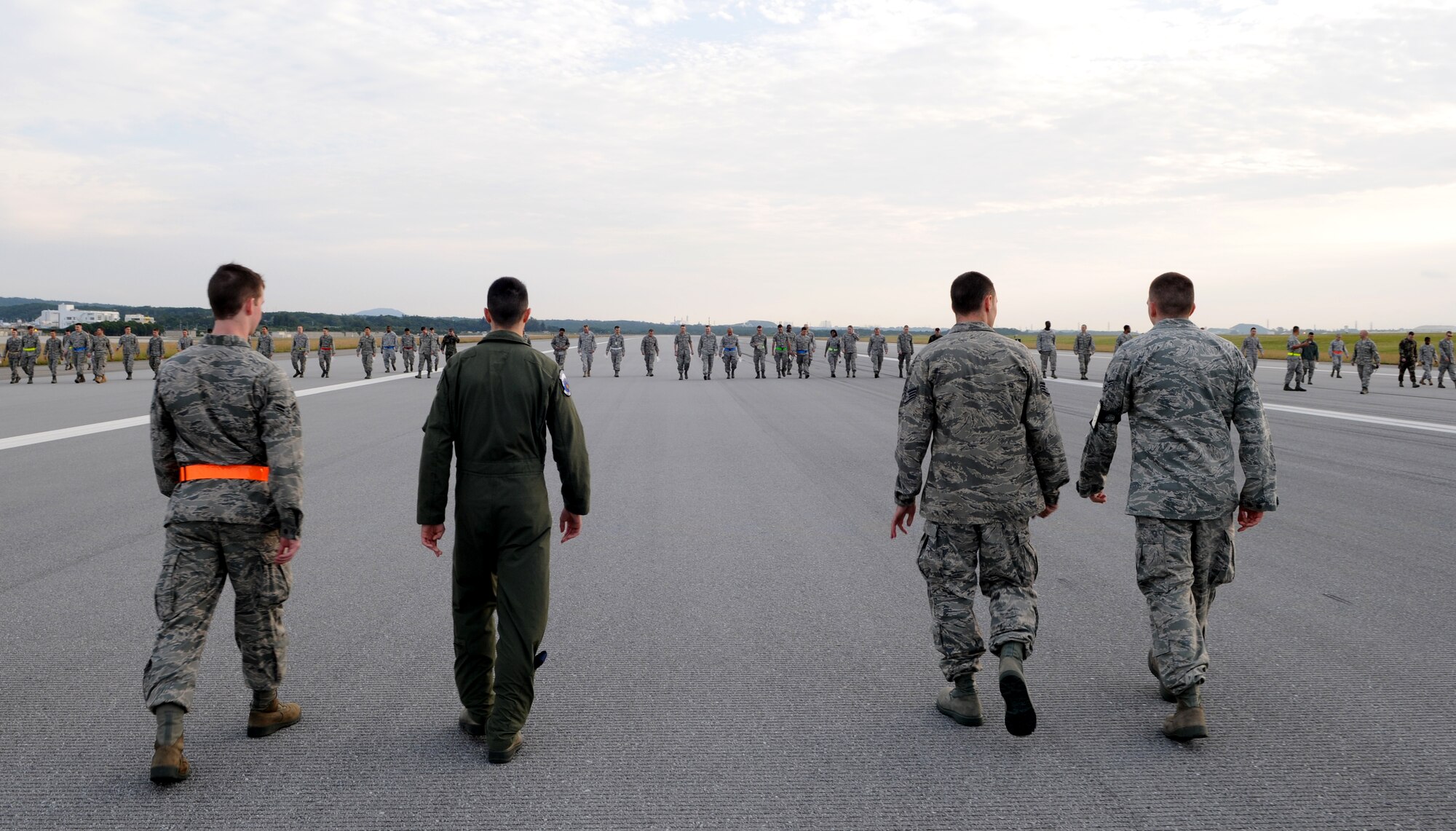 Members of the 18th Wing participate in a Foreign Object Damage (FOD) walk on the Kadena AB flightline Nov. 12. The purpose of FOD walks is to keep the airfield clean and free of damaging debris such as aircraft and vehicle fasteners, rocks and any hard or soft objects that can damage an aircraft engine or airframe. (U.S. Air Force photo/Airman 1st Class Jarvie Wallace)