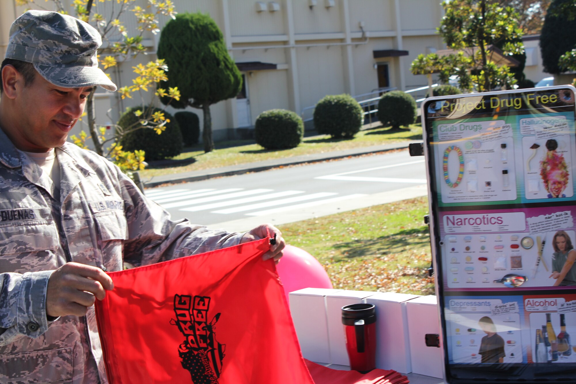 YOKOTA AIR BASE, Japan -- Chief Master Sgt. David Duenas, 374th Medical Group, picks out a free bag at the information table during the medication drop-off event here, Nov. 10. The event kicked off the Lock Your Meds campaign, sponsored by the Drug Demand Reduction Program. The campaign aims to encourage people to safeguard medications and properly discard any that are no longer needed. (U.S. Air Force photo submission/Sequoiya Lawson)