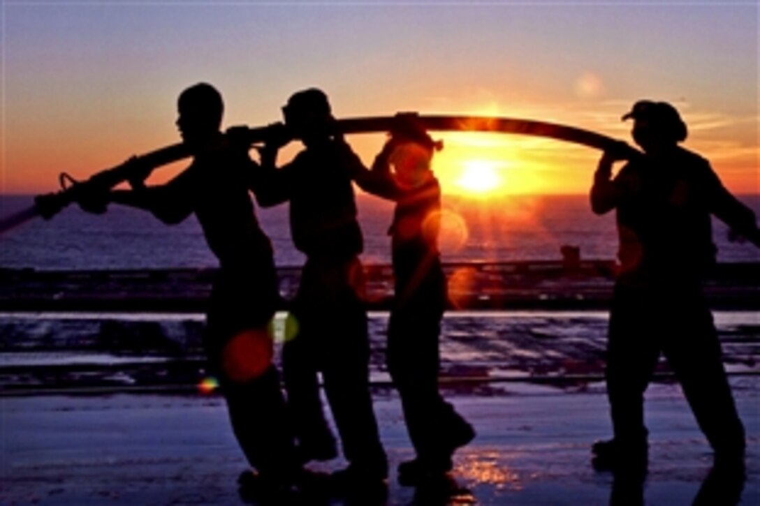 U.S. Navy sailors hose down the flight deck of the aircraft carrier USS Ronald Reagan with seawater during a scrub exercise in the Pacific Ocean, Nov. 14, 2010. The exercise is necessary to clean salt water spray off the skin of the ship to prevent corrosion. The Ronald Reagan is preparing for an upcoming deployment.