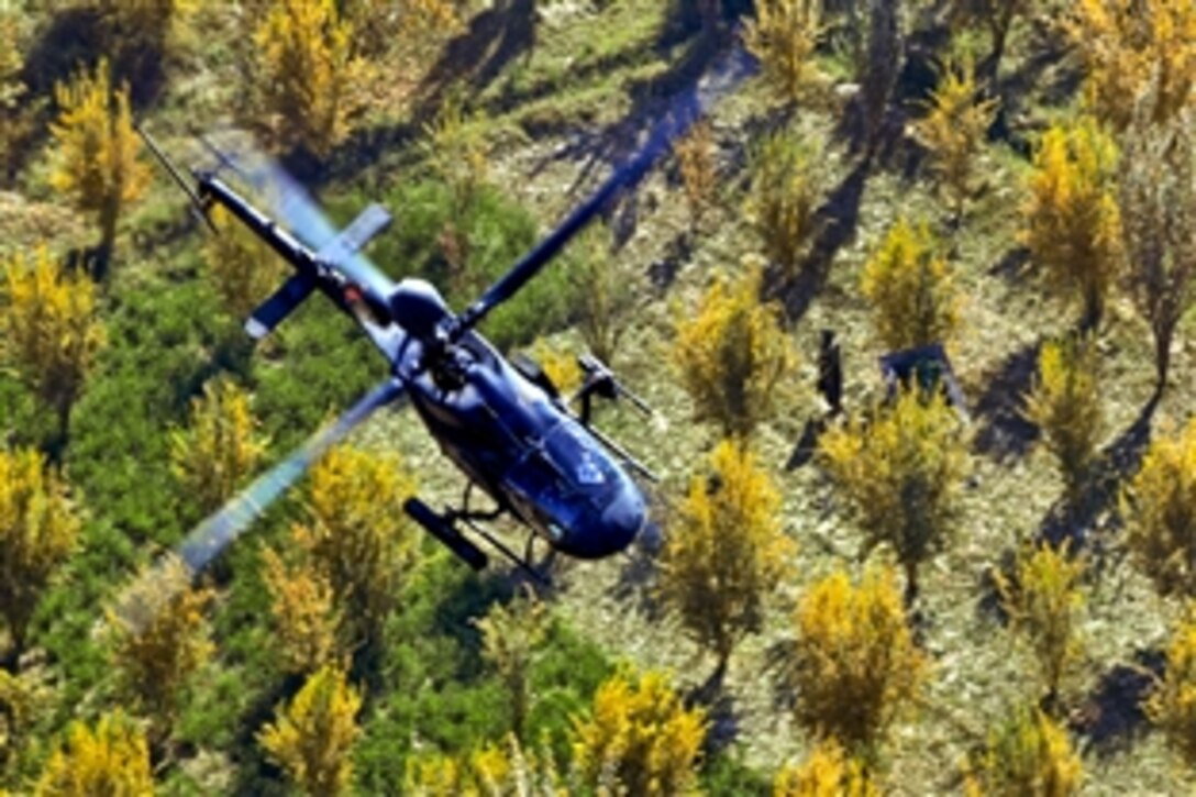A U.S. Army OH-58D Kiowa Warrior helicopter flies over the tree tops and a Afghan farmer 
during an aerial reconnaissance mission in southern Afghanistan, Nov. 8, 2010. The OH-58D crew is assigned to 101st Combat Aviation Brigade.