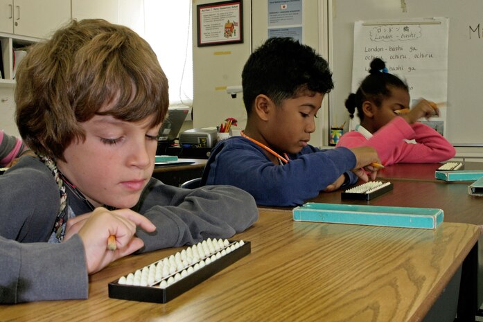 Students practice using their sorobans during a training session from Miyuki Inoashi, a master teacher of soroban, at Matthew C. Perry Elementary School here Nov. 16. The tool is used to calculate various types of mathematical equations.
