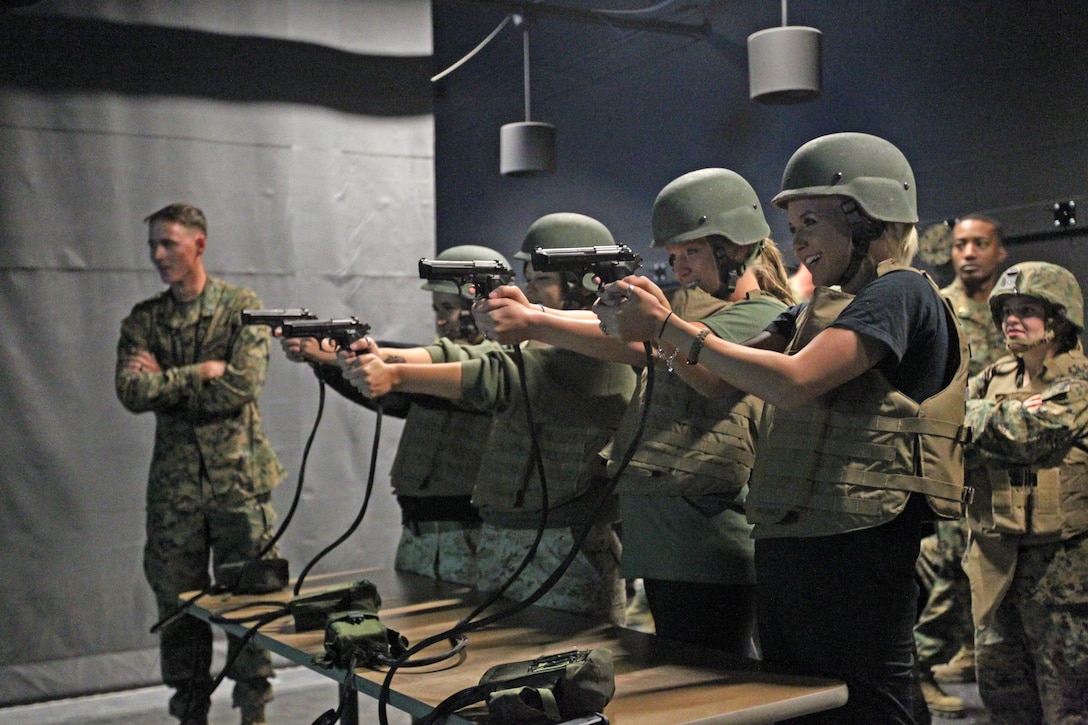 Wives with 2nd Battalion, 7th Marine Regiment’s Jane Wayne Day fire off rounds at the Indoor Simulated Marksmanship Trainer during their trip there Wednesday. The day is meant to build camaraderie amongst spouses within the battalion. ::r::::n::