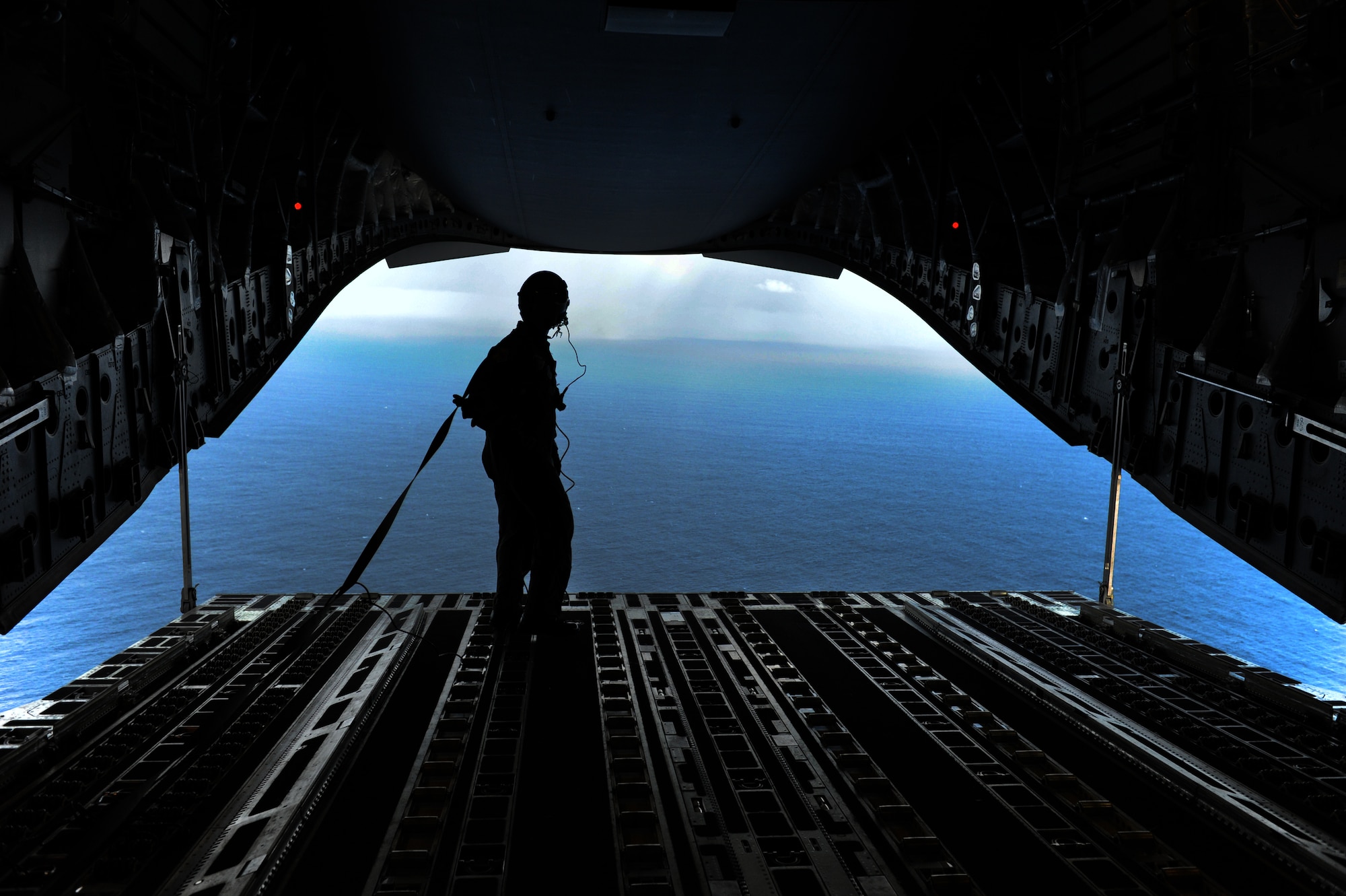 Staff Sgt. Jason Jones, 535th Airlift Squadron loadmaster, enjoys the view over the Pacific Ocean, just off the Northern coast of Oahu, Hawaii, during a two-ship airdrop mission. The 535th AS aircrew trained in unrestricted descent assault landings, air drop, combat offloads, air refueling, night vision goggle training, combat offloads, low levels, mountainous terrain, assault landings, threat responses and multiple ship formation training during a five day training trip to Washington Nov 12-17. (U.S. Air Force photo/Staff Sgt. Mike Meares)