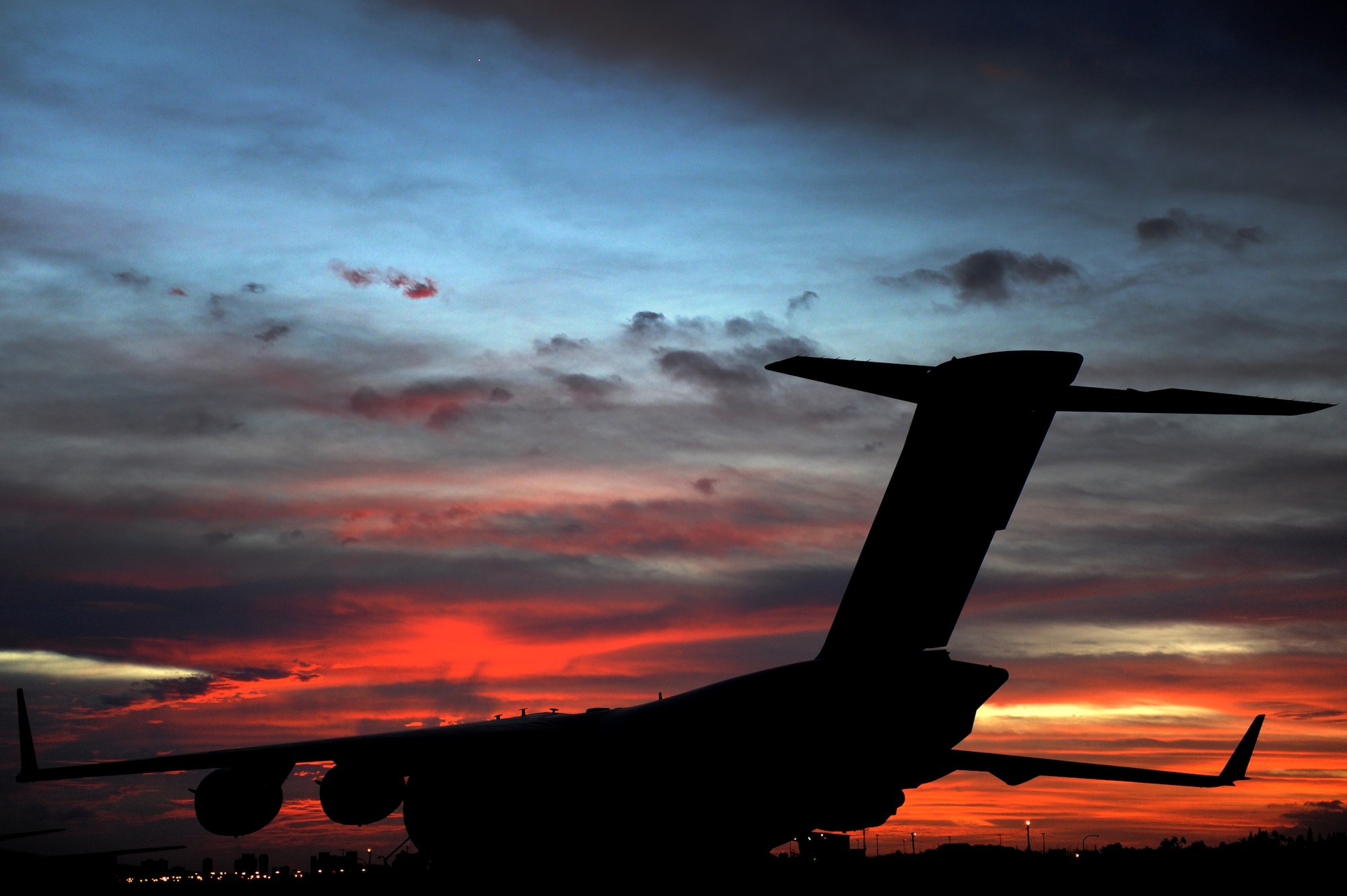 C-17 Globemaster III, tail number 05-5150, sits on the Hickam runway at sunrise awaiting a 535th Airlift Squadron aircrew to begin an airdrop mission and multiday training exercises Nov.12. The 535th AS aircrew trained in unrestricted descent assault landings, air drop, combat offloads, air refueling, night vision goggle training, combat offloads, low levels, mountainous terrain, assault landings, threat responses and multiple ship formation training during a five day training trip to Washington Nov 12-17. (U.S. Air Force photo/Staff Sgt. Mike Meares)