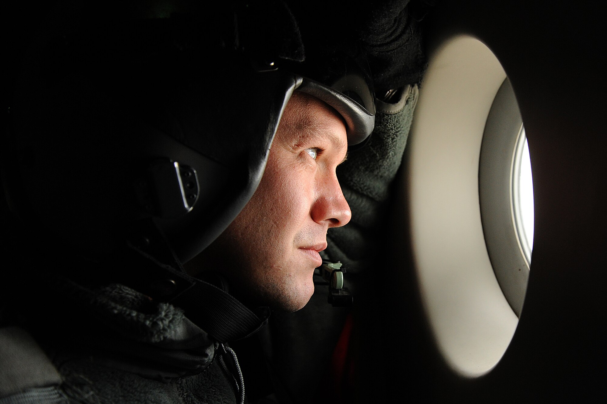 Staff Sgt. Jason Jones, 535th Airlift Squadron loadmaster, looks out over the mountainous terrain of the Pacific Northwest during a training mission Nov. 13 at Joint Base Lewis-McChord. The 535th AS aircrew trained in unrestricted descent assault landings, air drop, combat offloads, air refueling, night vision goggle training, combat offloads, low levels, mountainous terrain, assault landings, threat responses and multiple ship formation training during a five day training trip to Washington Nov 12-17. (U.S. Air Force photo/Staff Sgt. Mike Meares)