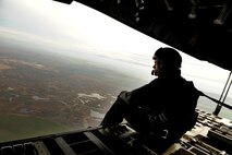 Staff Sgt. Jason Jones, 535th Airlift Squadron loadmaster, enjoys the view over Grant County, Wash., during a training mission Nov. 13 at Joint Base Lewis-McChord. The 535th AS aircrew trained in unrestricted descent assault landings, air drop, combat offloads, air refueling, night vision goggle training, combat offloads, low levels, mountainous terrain, assault landings, threat responses and multiple ship formation training during a five day training trip to Washington Nov 12-17. (U.S. Air Force photo/Staff Sgt. Mike Meares)