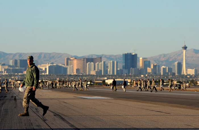 NELLIS AIR FORCE BASE, Nev. -- Col. Daniel Flood with the 99th Medical Group, walks across the Nellis Flightline looking for trash during a Foreign Object Debris walk Nov. 15. The base wide FOD walk was conducted following the 2010 Aviation Nation  Nellis Open House which had an estimate 145,000 people from the local Las Vegas community attend. FOD prevention is every individual's responsibilities as it can cost millions of dollars of damage to aircraft systems and personnel. (U.S. Air Force photo by Senior Airman Brett Clashman)(Released)
