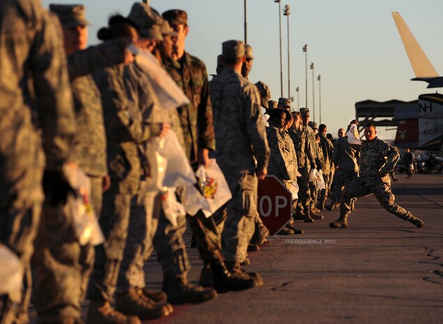 NELLIS AIR FORCE BASE, Nev. -- Staff Sgt. Branden Coneita, aerospace medical technician with the 99th Medical Group, A.K.A. "FOD Man" poses and flexes his arms in an attempt to motivate his fellow Airmen before a Foreign Object Debris walk across the Nellis flightline Nov. 15. A FOD walk is a way of removing any foreign object or debris from a flightline to prevent potential damage to aircraft. (U.S. Air Force photo by Senior Airman Brett Clashman)(Released)