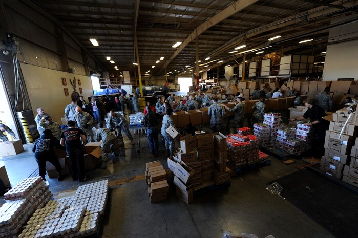 NELLIS AIR FORCE BASE, Nev. -- Nellis volunteers put Thankgiving gift baskets together during Operation Warmheart, Nov. 12. Nellis Airmen volunteered Friday morning to help create packages, and fill them with Thanksgiving meal items, so they can be delivered to homes and work centers. (U.S. Air Force photo by Senior Airman Brett Clashman)(Released)