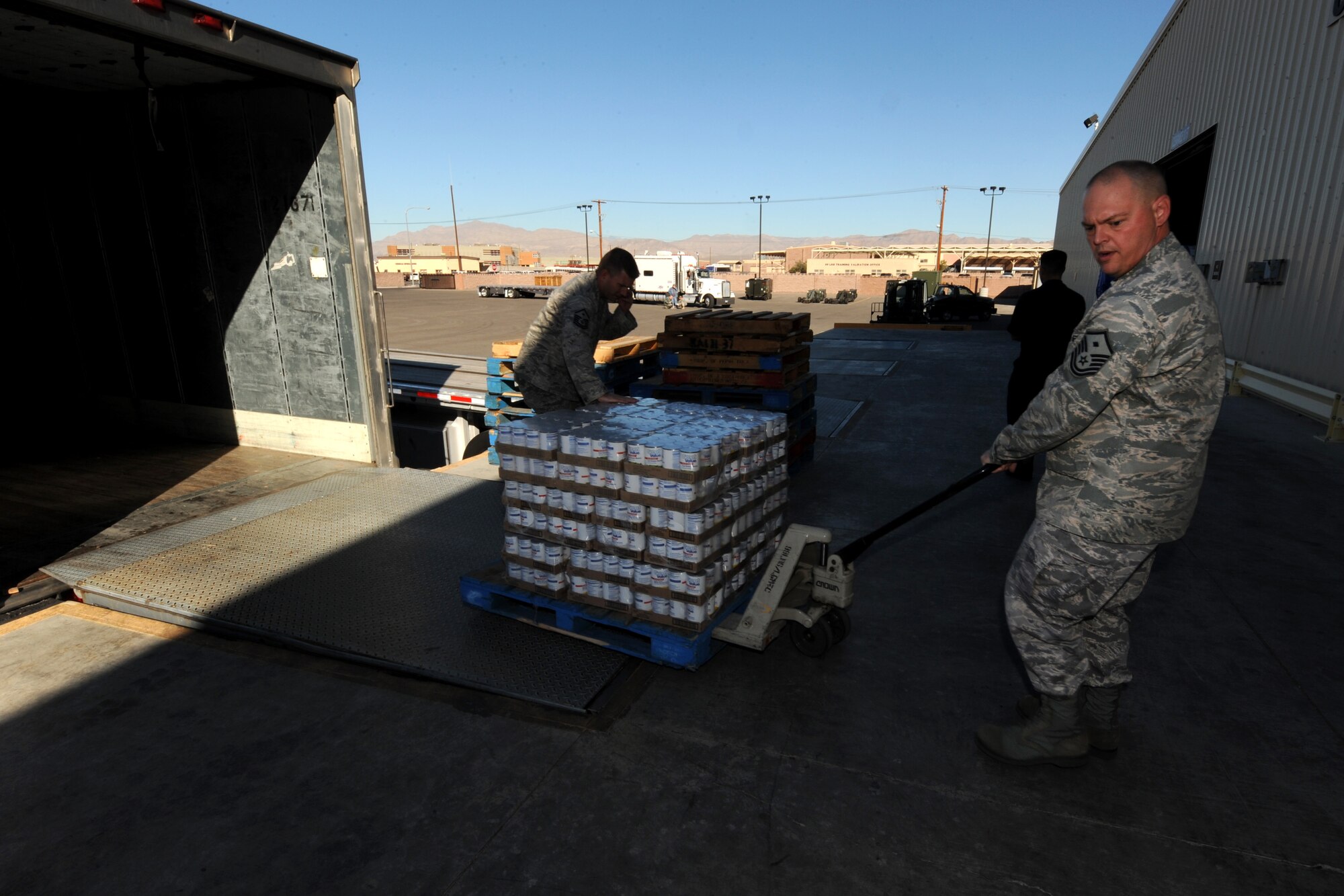 NELLIS AIR FORCE BASE, Nev. -- Master Sgt. Robert Workman, first sergeant with the U.S. Air Force Weapons School, pulls a palette of groceries during Operation Warmheart, Nov. 12. Nellis Airmen volunteered Friday morning to help create packages, and fill them with Thanksgiving meal items, so they can be delivered to homes and work centers. (U.S. Air Force photo by Senior Airman Brett Clashman)(Released)
