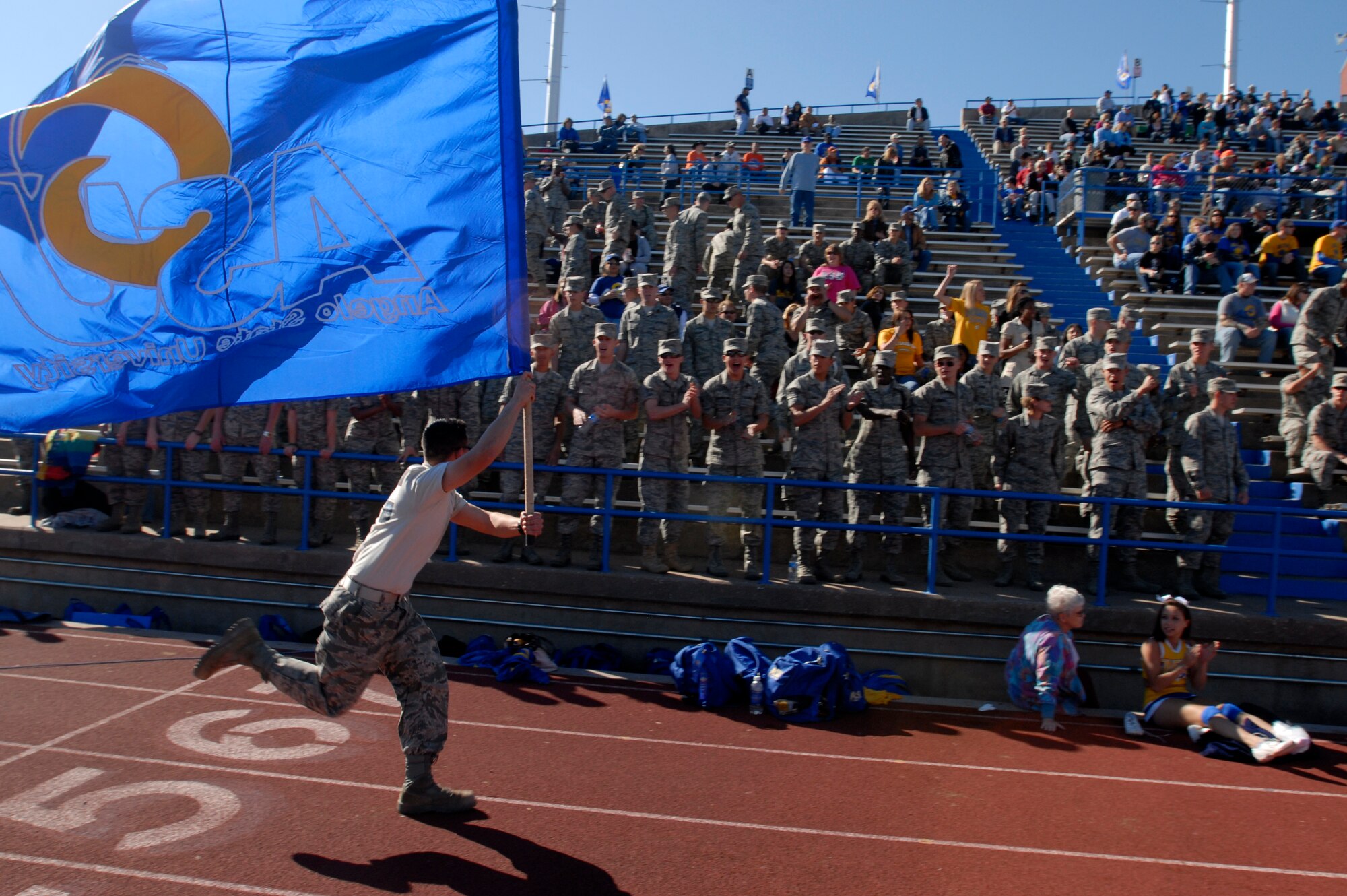 17th Training Wing Airmen cheer as a cadet from the Air Force Reserve Officer Training Corps Detachment 847 Angelo State University, San Angelo, Texas runs the length of the field to celebrate a touchdown during the Angelo State vs. Central Oklahoma football game Nov. 13. Angelo State University and local groups sponsored several events to show their appreciation to all active duty and retired military personnel and their families. (U.S. Air Force photo/Master Sgt. Randy Mallard)