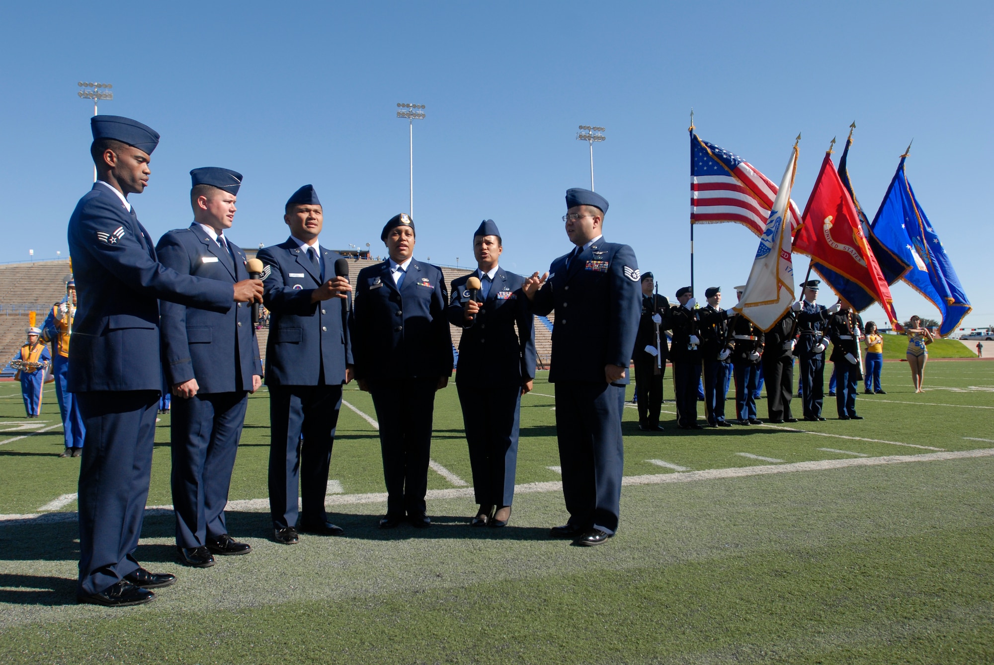 Patriotic Blue, a singing group made up of active duty members from the 17th Training Wing, sings the National Anthem as the Goodfellow Joint Service Color Guard present the Colors before the start of the Angelo State vs. Central Oklahoma football game Nov. 13.  Angelo State University and local groups sponsored several events to show their appreciation to all active duty and retired military personnel and their families. (U.S. Air Force photo/Master Sgt. Randy Mallard)