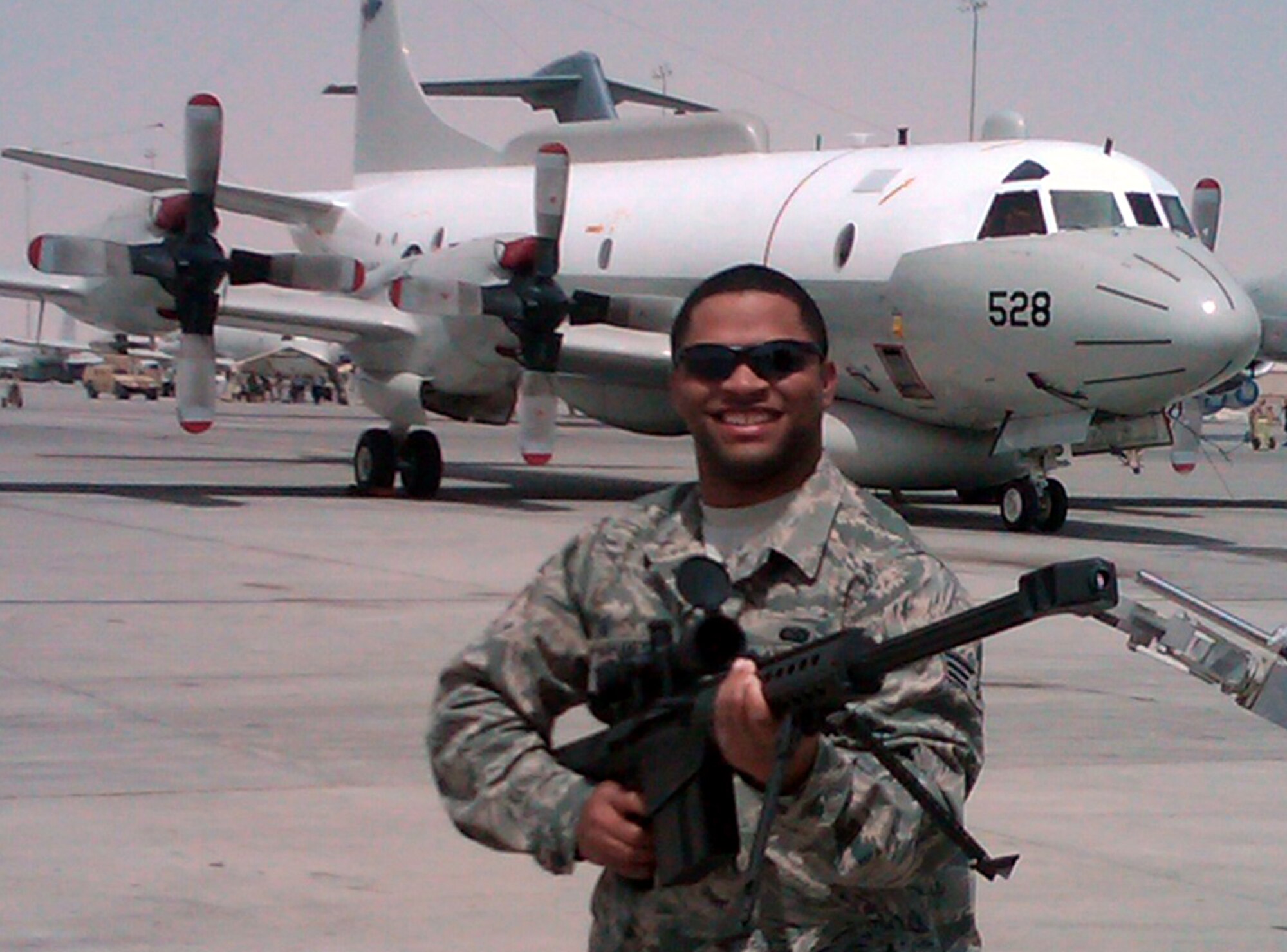 SOUTHWEST ASIA -- Senior Airman Ricky Mahaney, 509th Force Support Squadron force management operations representative, holds a display-sniper rifle at an air show while deployed. Airman Mahaney said the show was a moral booster for deployed Airmen. (Courtesy Photo)