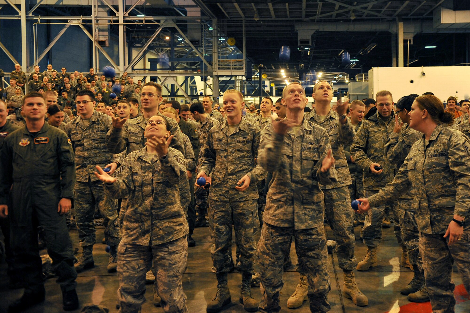 OFFUTT AIR FORCE BASE, Neb. -- Members of the 55th Wing juggle balls during a 55th WG Wingman Day 2010 commander's call Nov. 12 in the Bennie Davis Maintenance Facility's Dock One.  Airmen in the 55th Wing took part in various events and briefings during the day to promote teamwork and educate Airmen on topics such as suicide prevention and the dangers of drinking and driving. U.S. Air Force photo by Charles Haymond
