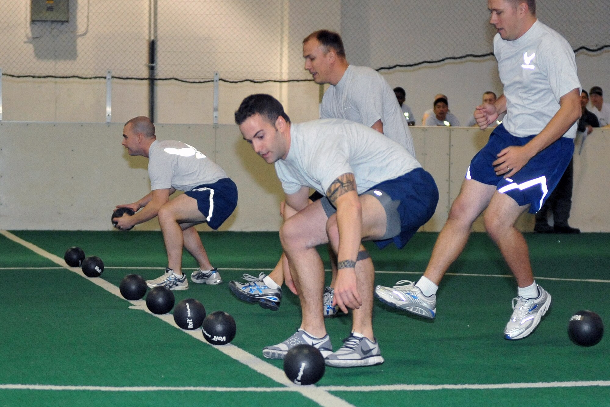 OFFUTT AIR FORCE BASE, Neb. - Members of the 55th Intelligence Support Squadron lunge to grab balls for the the dodge ball competition at the Offutt Field House Nov. 12 during Wingman Day 2010. Airmen in the 55th Wing took part in various events and briefings during the day to promote teamwork and educate Airmen on topics such as suicide prevention and the dangers of drinking and driving. U.S. Air Force photo by Jeff W. Gates. 