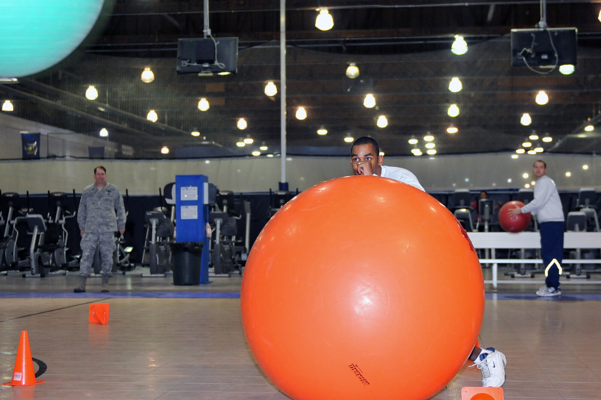 OFFUTT AIR FORCE BASE, Neb. - Staff Sgt. Sam Cruz, a member of the 55th Aerospace Medicine Squadron Public Health Flight, dodges a ball during the mega ball challange event in the Offutt Field House Nov. 12 while Brig. Gen. John N.T. Shanahan, 55th Wing commander watches the competition. Airmen in the 55th Wing took part in a variety of events and attended briefings during the 2010 Wingman Day to promote teamwork and provide education on things like suicide prevention and the dangers of drinking and driving.  U.S. Air Force photo by Jeff W. Gates. 