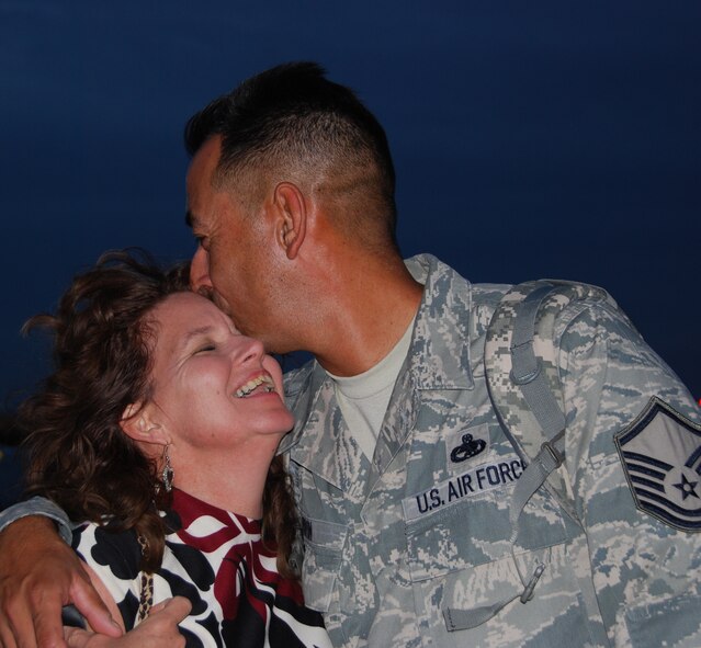 After a 45-day deployment to Korea in support of U.S. Pacific Command's Theater Security Package, Master Sgt. Eloy Vinton, 301st Maintenance Group quality assurance inspector at NAS Fort Worth JRB, Texas, gives his wife a kiss among a crowd of a hundred other family members greeting the return of their Airmen. (U.S. Air Force photo/Laura Dermarderosiansmith)