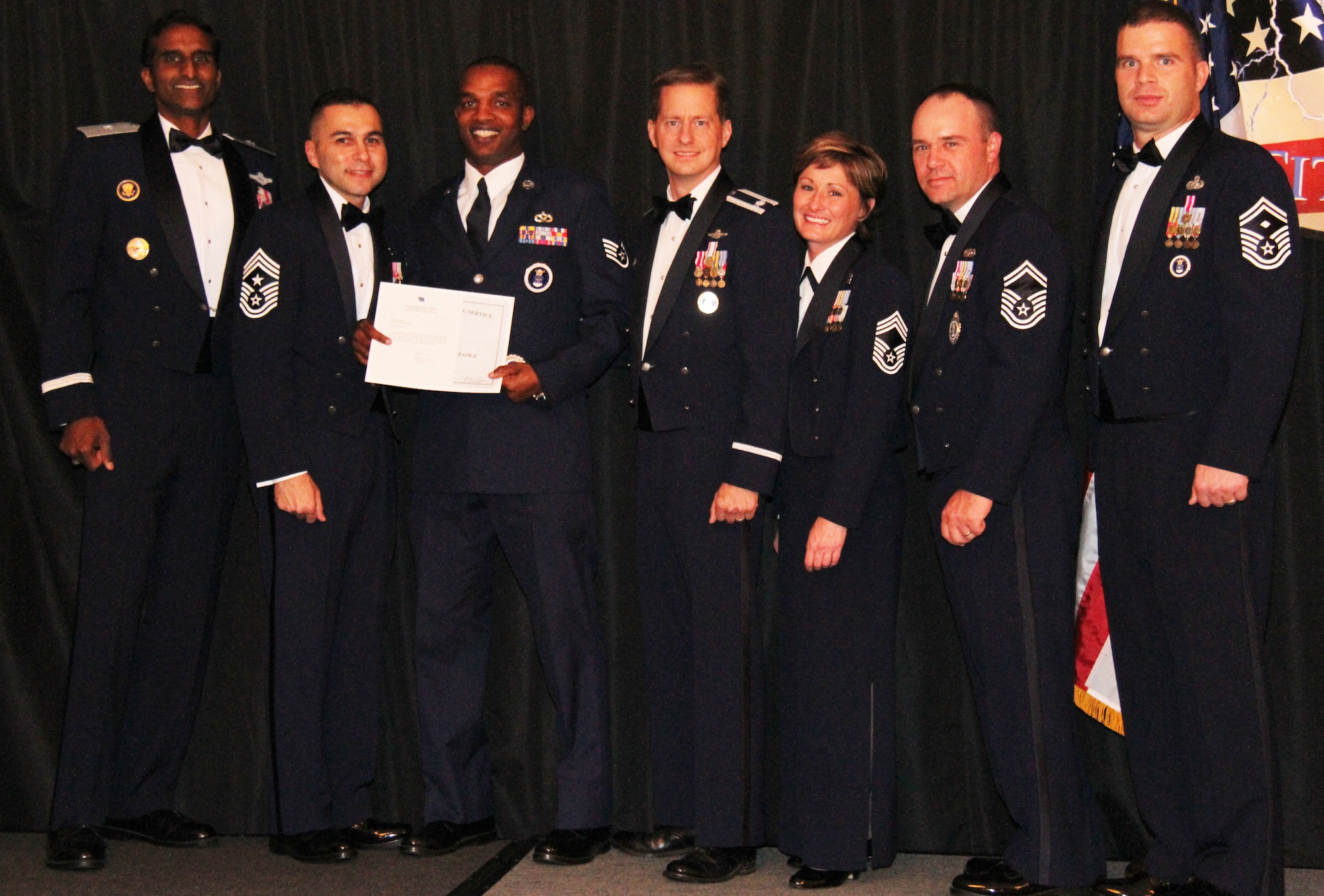 Staff Sgt. Justin Nixon, a recruiter from Hattiesburg, Miss., displays his certificate for receiving his first Senior Recruiting Badge at the 345th Recruiting Squadron’s annual awards banquet. With Sergeant Nixon are (from left): Brig. Gen. Balan R. Ayyar, commander of Air Force Recruiting Service; AFRS Command Chief Master Sgt. Ruben Gonzalez Jr.; Sergeant Nixon; Lt. Col. Christopher Byrom, commander of the 345th RCS; Chief Master Sgt. Robin Hurst, superintendent, 345th RCS; Senior Master Sgt. Wade Trahan, production superintendent, 345th RCS; and Senior Master Sgt. Lee Thul, first sergeant, 345th RCS. (U.S. Air Force photo)