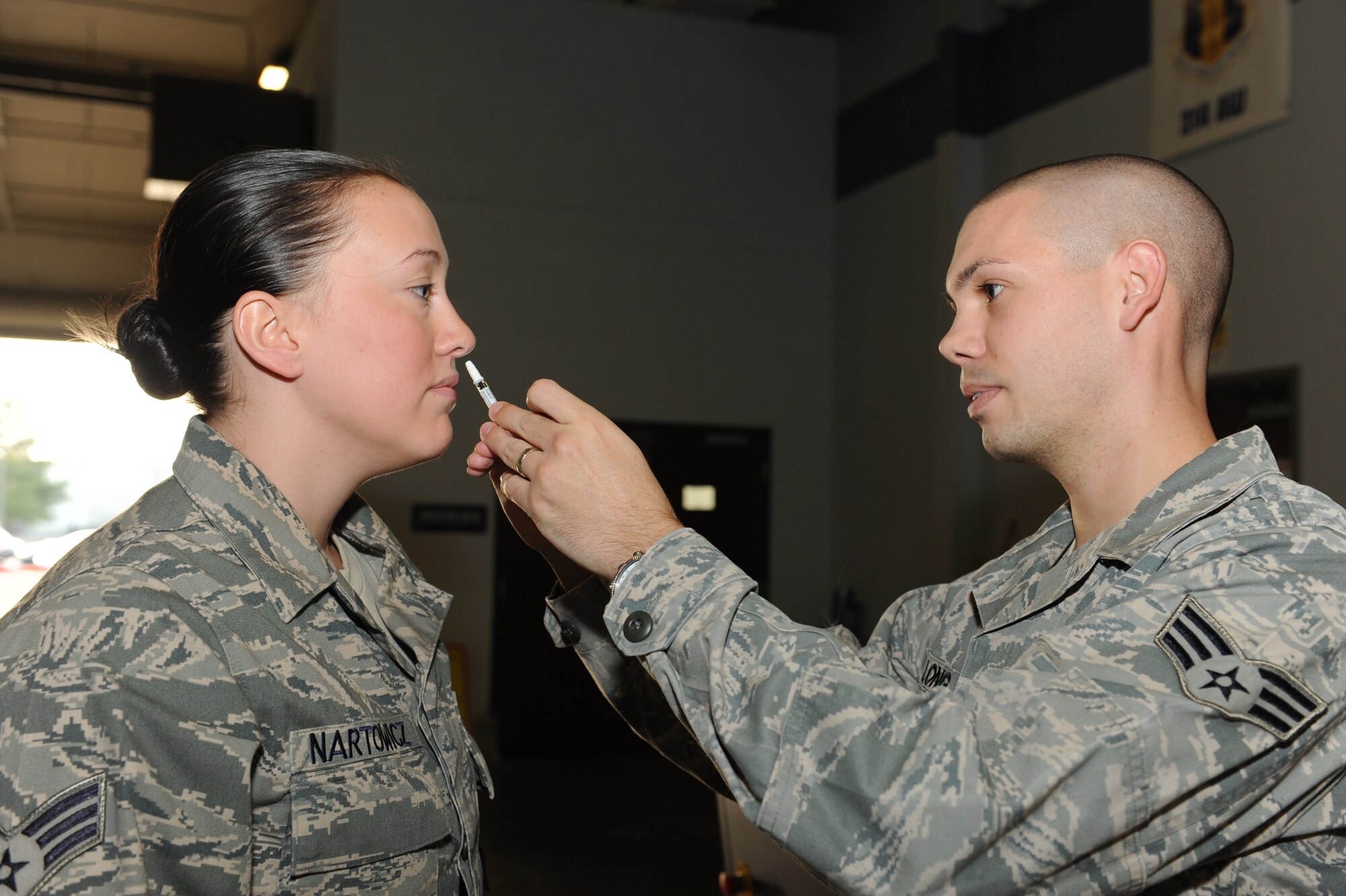 Senior Airman Douglas Long, 19th Aerospace Medical Squadron bioenvironmental engineer, shoots flu mist up the nose of Senior Airman Jasmine Nartowics, 19th Aircraft Maintenance Squadron debrief specialist, Nov. 8, 2010, at the passenger terminal at Little Rock Air Force Base, Ark. More than 1,900 military members received flu vaccinations Nov. 8 and 9, 2010, as part of annual prevention precautions. Shots for retirees and family members are also available. For more information, call immunizations at 987-7312. (U.S. Air Force photo by Airman 1st Class Ellora Stewart)