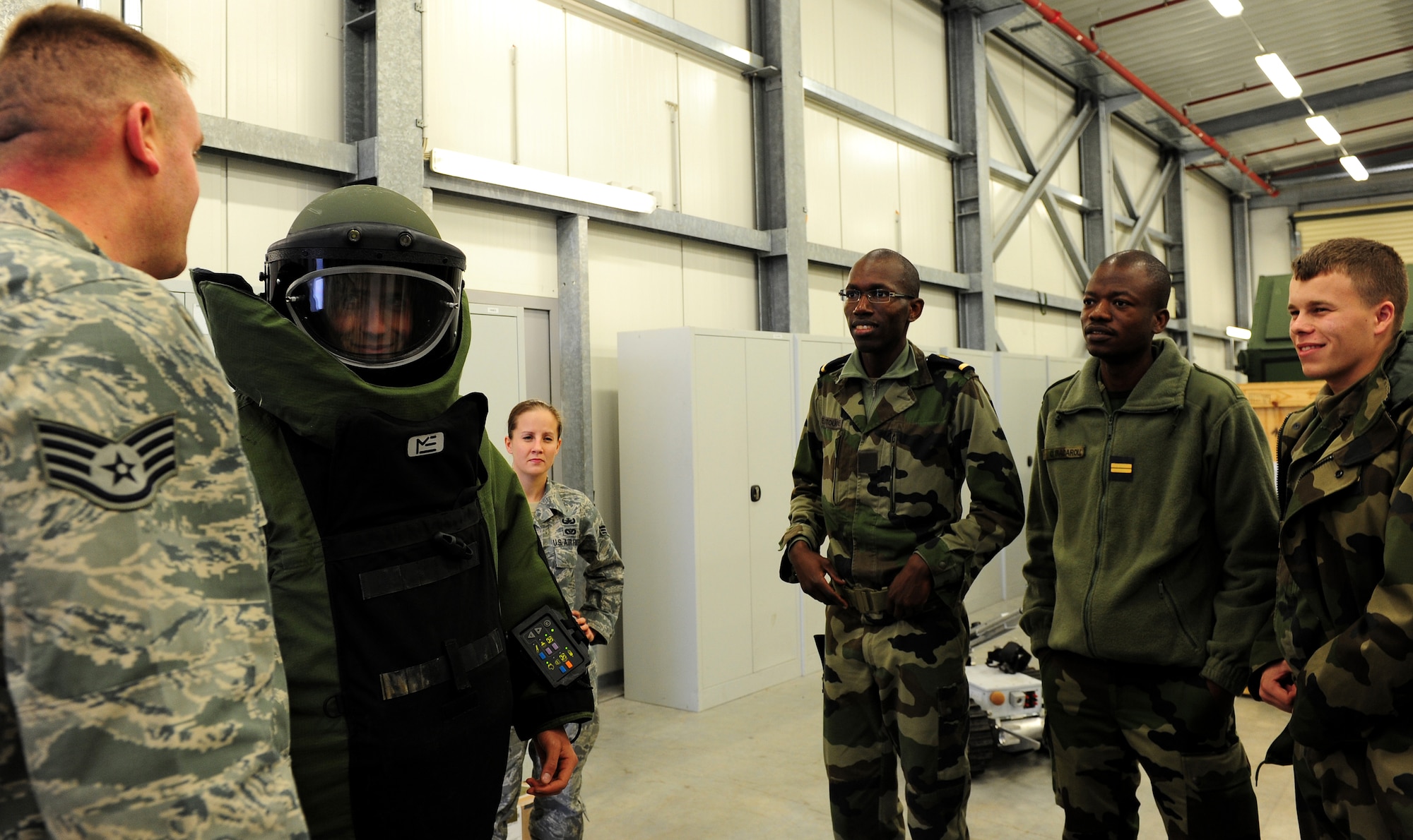 U.S. Air Force Staff Sgt. Kristopher Parker, 886th Civil Engineer Squadron, briefs French air force cadets on the significance of the Explosive Ordnance Disposal 9 bomb suit, Ramstein Air Base, Germany, Nov. 16, 2010. The cadets will be visiting several locations on base during the tour.(U.S. Air Force photo by Airman 1st Class Brea Miller)