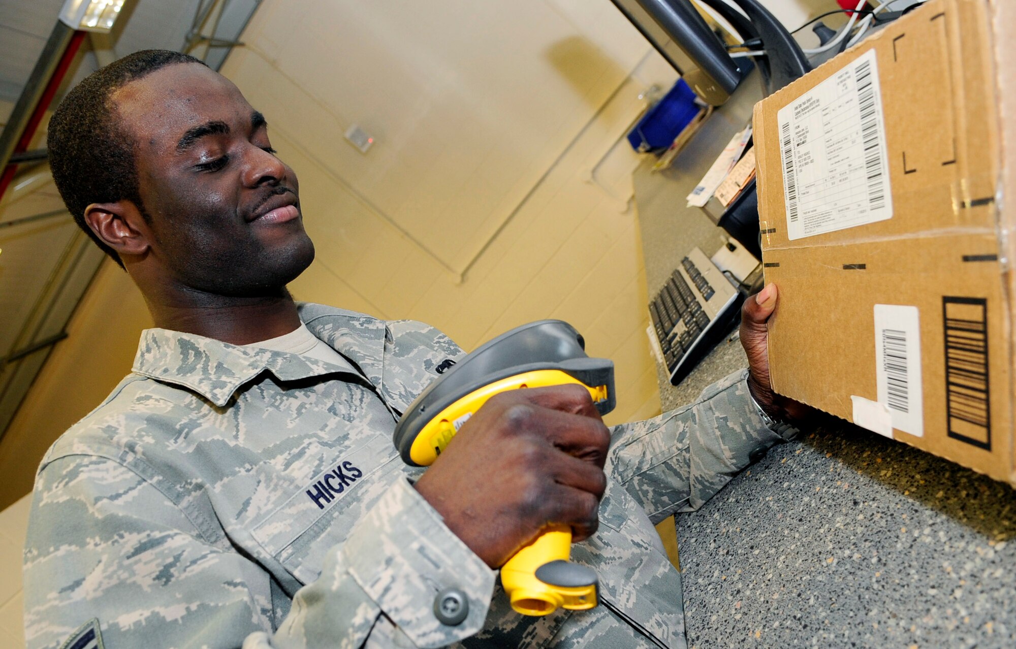 RAF MILDENHALL, England -- Staff Sgt. Dustin Hicks, 100th Communications Squadron postal specialist, scans a package before passing it along to a customer at the base post office Nov. 15, 2010. To ensure that everyone's packages reach their destinations on time the post office has put deadlines into effect  that include Nov. 26 for standard parcel post, Dec. 10 for priority and first class, and Dec. 17 for express mail. (U.S. Air Force photo/Senior Airman Ethan Morgan)