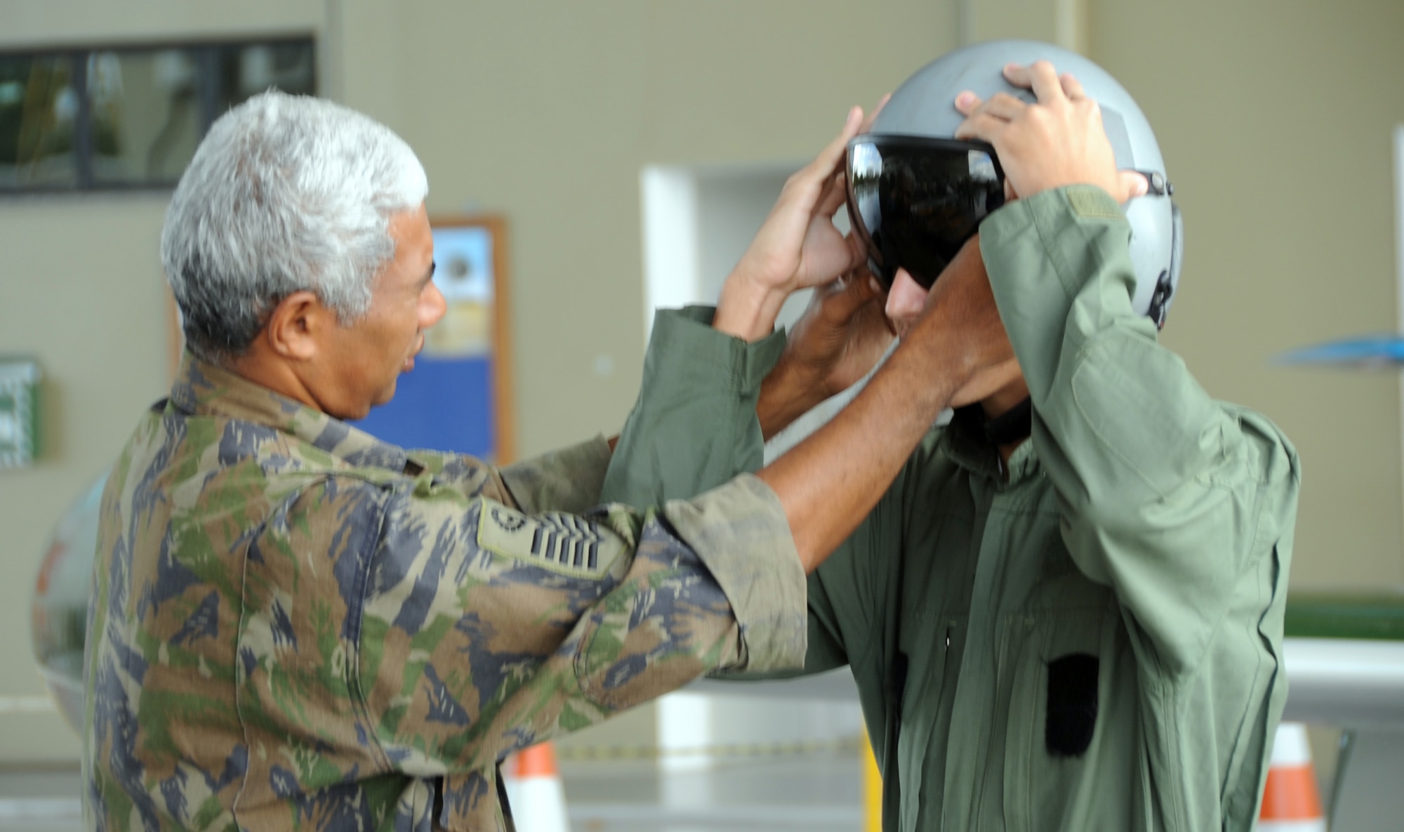 A local youth is fitted in a helmet during an open house at Natal Air Base, Brazil in conjunction with CRUZEX V. CRUZEX, or Cruzeiro Do Sul (Southern Cross), is a multi-national combined exercise involving the Air Forces of Argentina, Brazil, Chile, France and Uruguay, and observers from numerous other countries with more than 82 aircraft and almost 3,000 Airmen involved. (U.S. Air Force photo/Staff Sgt. Michael Matkin)