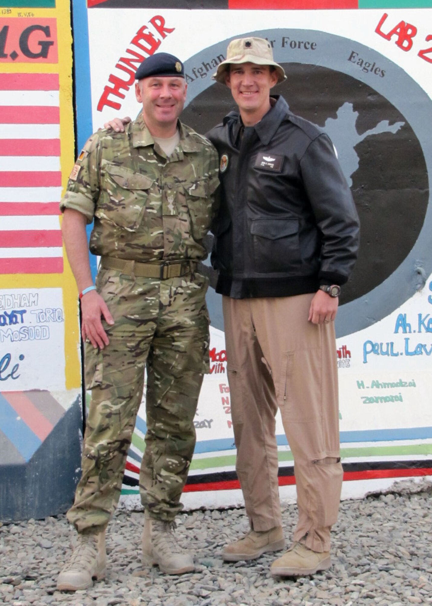 KABUL, Afghanistan - Lt. Col. John Howard (right), Officer-in-Charge of the Thunder Lab, Afghan Air Force English Immersion Lab located at Kabul International Airport, Afghanistan and Lt. Col. Michael W. Brown,Chief of Staff of the Combined Joint Movement Control Centre, Headquarters at ISAF Joint Command at KAIA, Afghanistan pose for a photo along side a mural located at the Thunder Lab.  Brown and Howard have known each other going back to their days as aides five years ago. (U.S.Navy photo by MC3 Jared E. Walker/RELEASED)