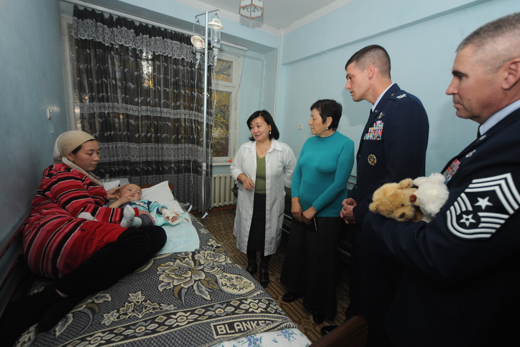 BISHKEK, Kyrgyzstan -  From right to left, Chief Master Sgt. James Lucas, 376th Air Expeditionary Wing command chief, Col. Dwight Sones, 376th Air Expeditionary Wing commander, and Ms. Valentina Turabekova, special assistant to the commander, talk with doctors and parents while providing gifts to patients at the Children's Cancer Center in Bishkek Nov. 13.  Members from the Transit Center at Manas visited the children as part of a team to assess the needs of the facility.  (U.S. Air Force photo/Staff Sgt. Nathan Bevier)