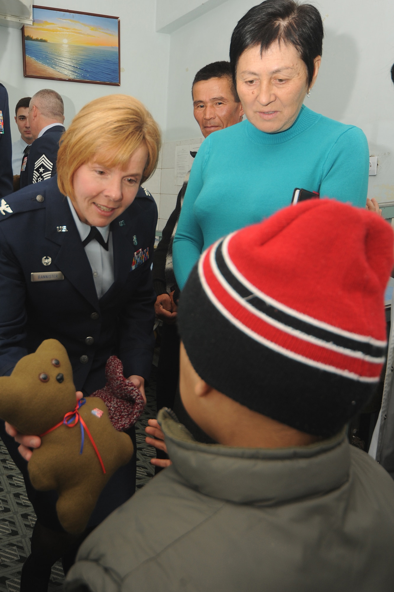 BISHKEK, Kyrgyzstan -  Col. Sharon Bannister, 376th Expeditionary Medical Group commander, gives a gift to a child at the Children's Cancer Center in Bishkek as Ms. Valentina Turabekova, special assistant to the 376th Air Expeditionary Wing commander, assists with translations Nov. 13.  Members from the Transit Center at Manas visited the children as part of a team to assess the needs of the facility.  (U.S. Air Force photo/Staff Sgt. Nathan Bevier)