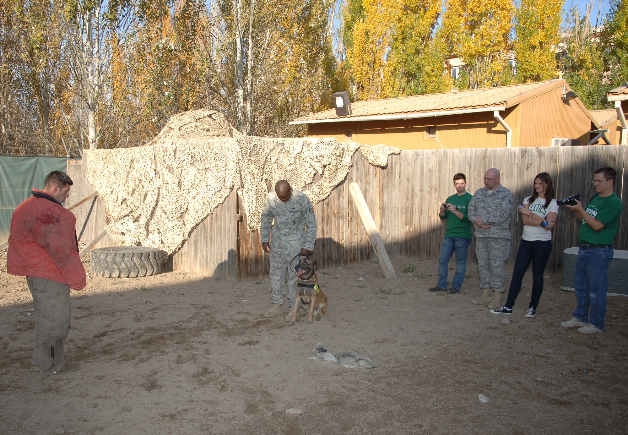 TRANSIT CENTER AT MANAS, Kyrgyzstan - Ms. Ayla Brown, American Idol semifinalist, and her band watch a military working dog demonstration during an Armed Forces Entertainment tour at the Transit Center at Manas Nov. 11.  Ms. Brown also received a cultural tour of Bishkek, a tour of a KC-135 Stratotanker and C-17 Globemaster III, Petroleum, Oil and Lubricants farm and  performed on stage at Pete's Place for over 500 deployed military members .  (U.S. Air Force photo/Master Sgt. Paul Cox)