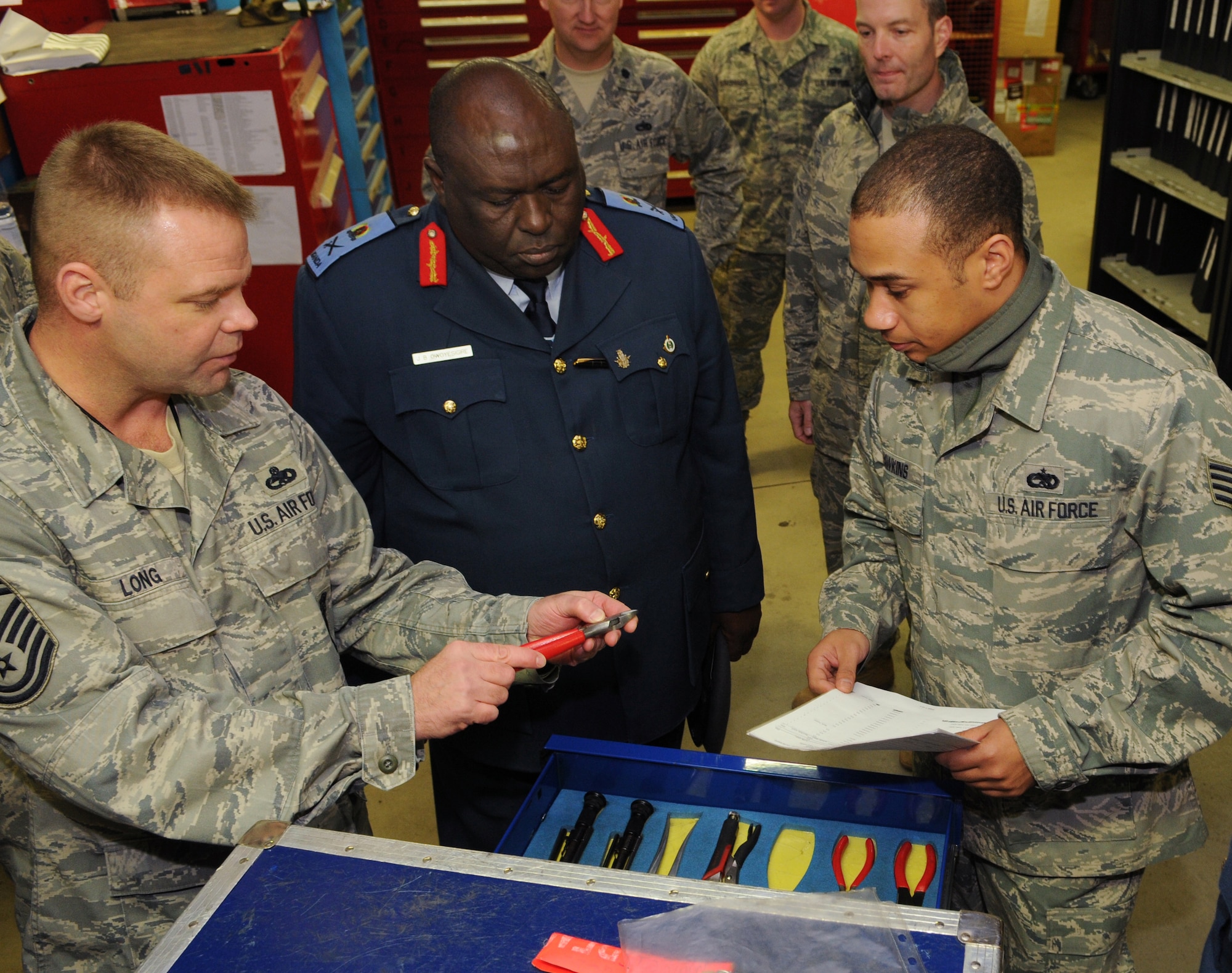 SPANGDAHLEM AIR BASE, Germany – Senior Master Sgt. Jeffery Long, left, 52nd Aircraft Maintenance Squadron weapons superintendant, explains the distinct markings on a pair of pliers while Staff Sgt. Anthony Hawkins, right, 52nd AMXS support technician, explains tool checkout procedures to Gen. Jim Beesigye Owoyesigire, Ugandan Peoples Defense Air Force commander, during his visit Nov. 10. General Owoyesigire toured several squadrons on Spangdahlem Air Base to gain a greater understanding of how the U.S. Air Force operates. (U.S. Air Force photo/Staff Sgt. Benjamin Wilson)