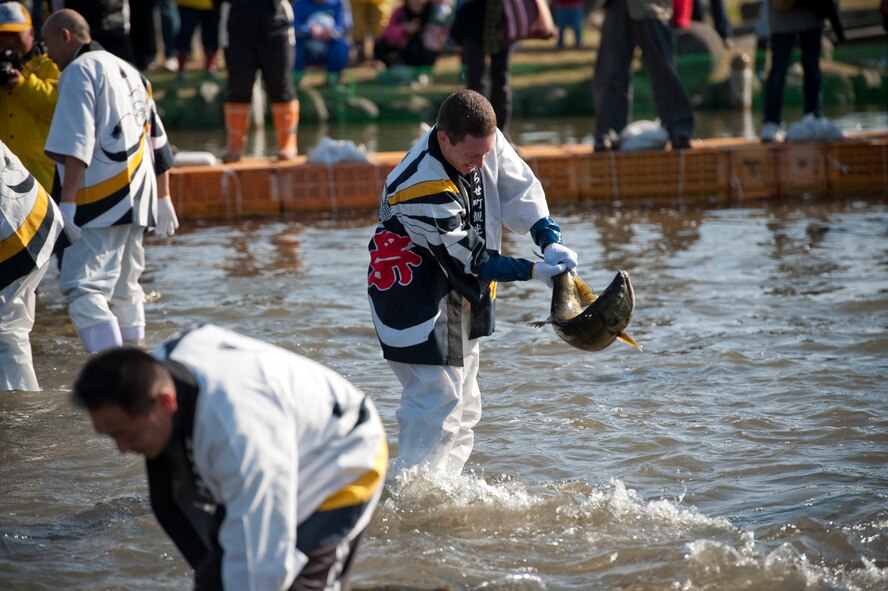 U.S. Air Force Col. Michael Rothstein, 35th Fighter Wing commander, catches a salmon at Salmon Park, Oirase, Japan, during the annual Oirase Salmon Catching Festival, Nov. 13, 2010. Local dignitaries and officials began the salmon catching by wrestling in the first catch of the day. (U.S. Air Force photo by Staff Sgt. Samuel Morse/Released)